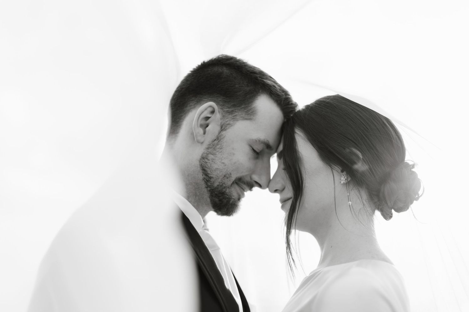 Black and white photo showing intimate moment between couple in wedding attire during their first dance.