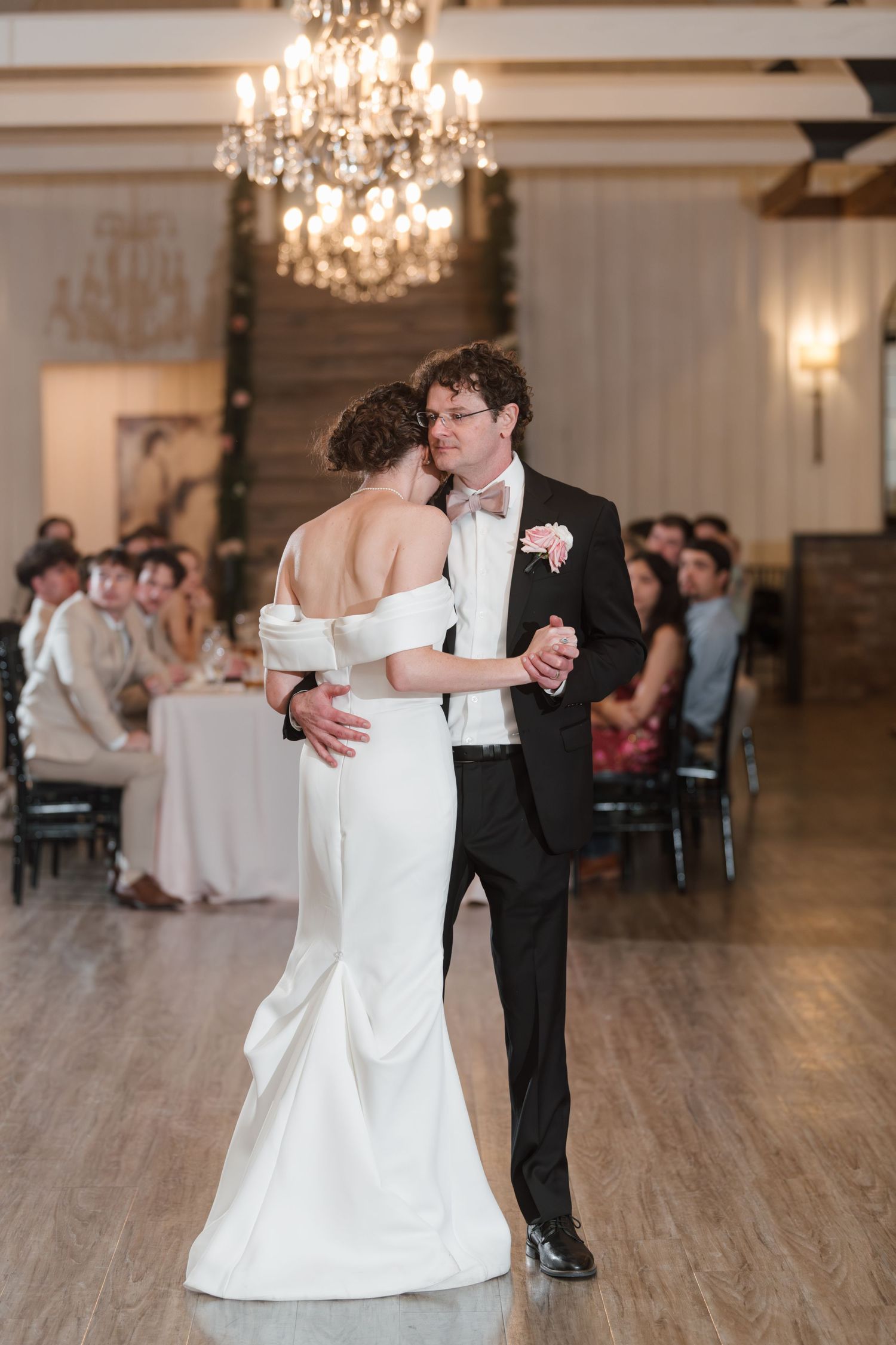 First dance sequence in elegant reception hall with chandelier lighting.