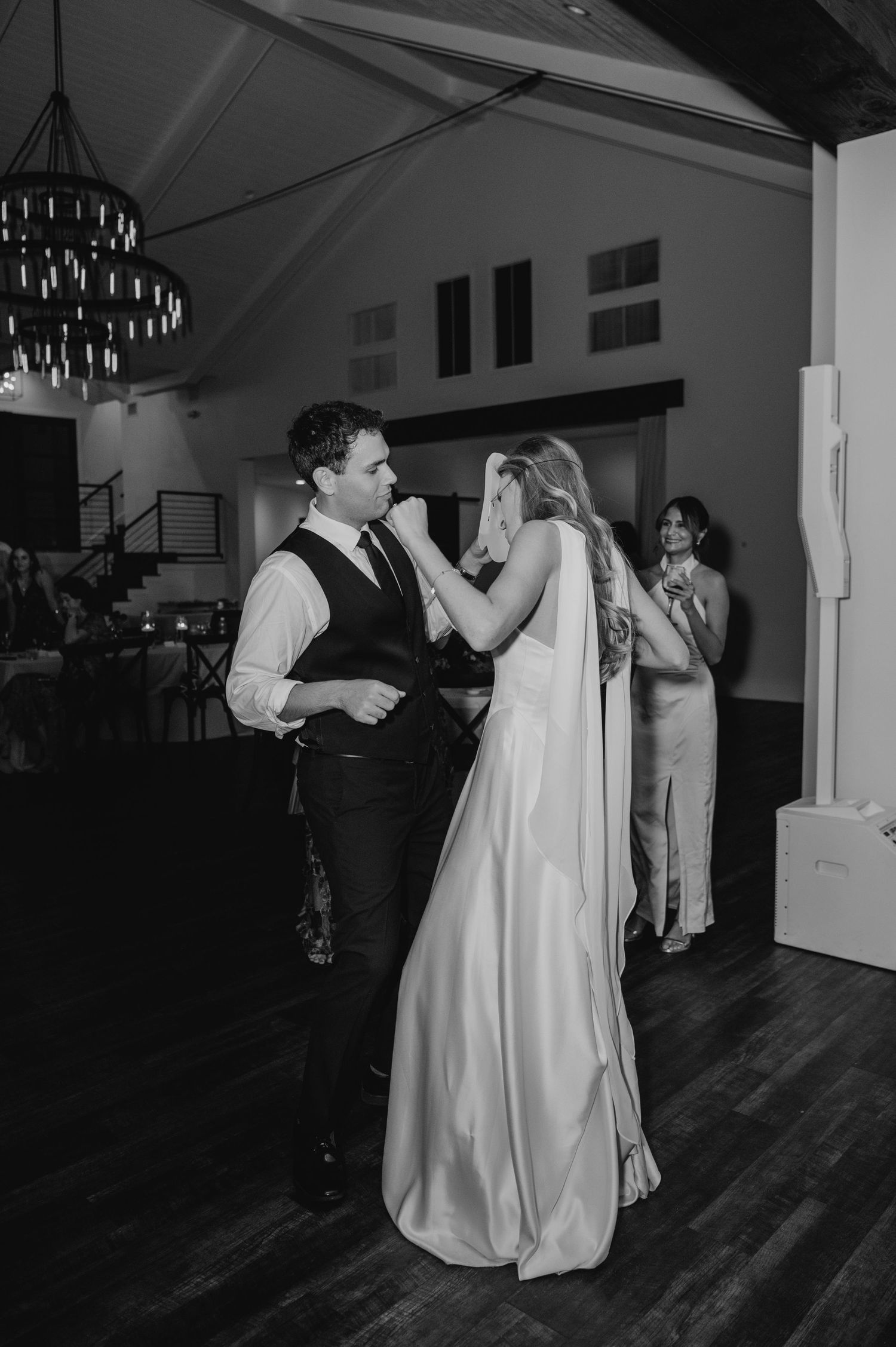 Wedding reception dance in black and white with couple dancing on wooden floor.