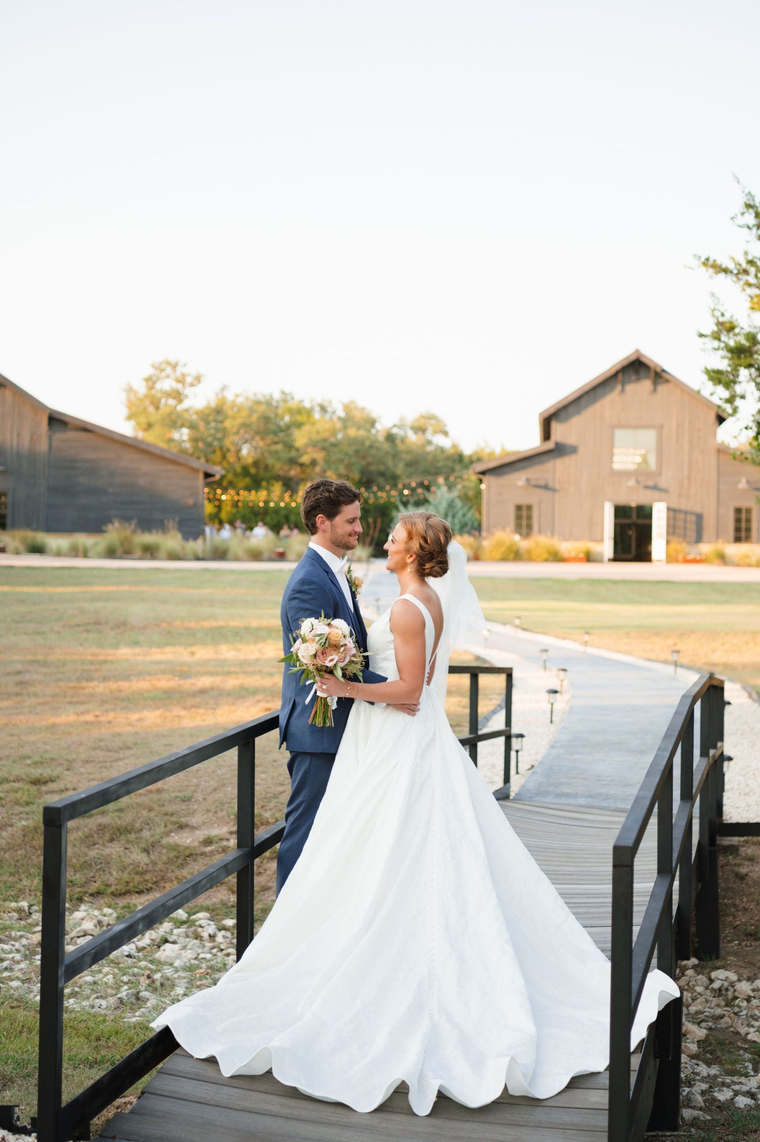 Romantic wedding couple shares intimate moments on a wooden deck at sunset.