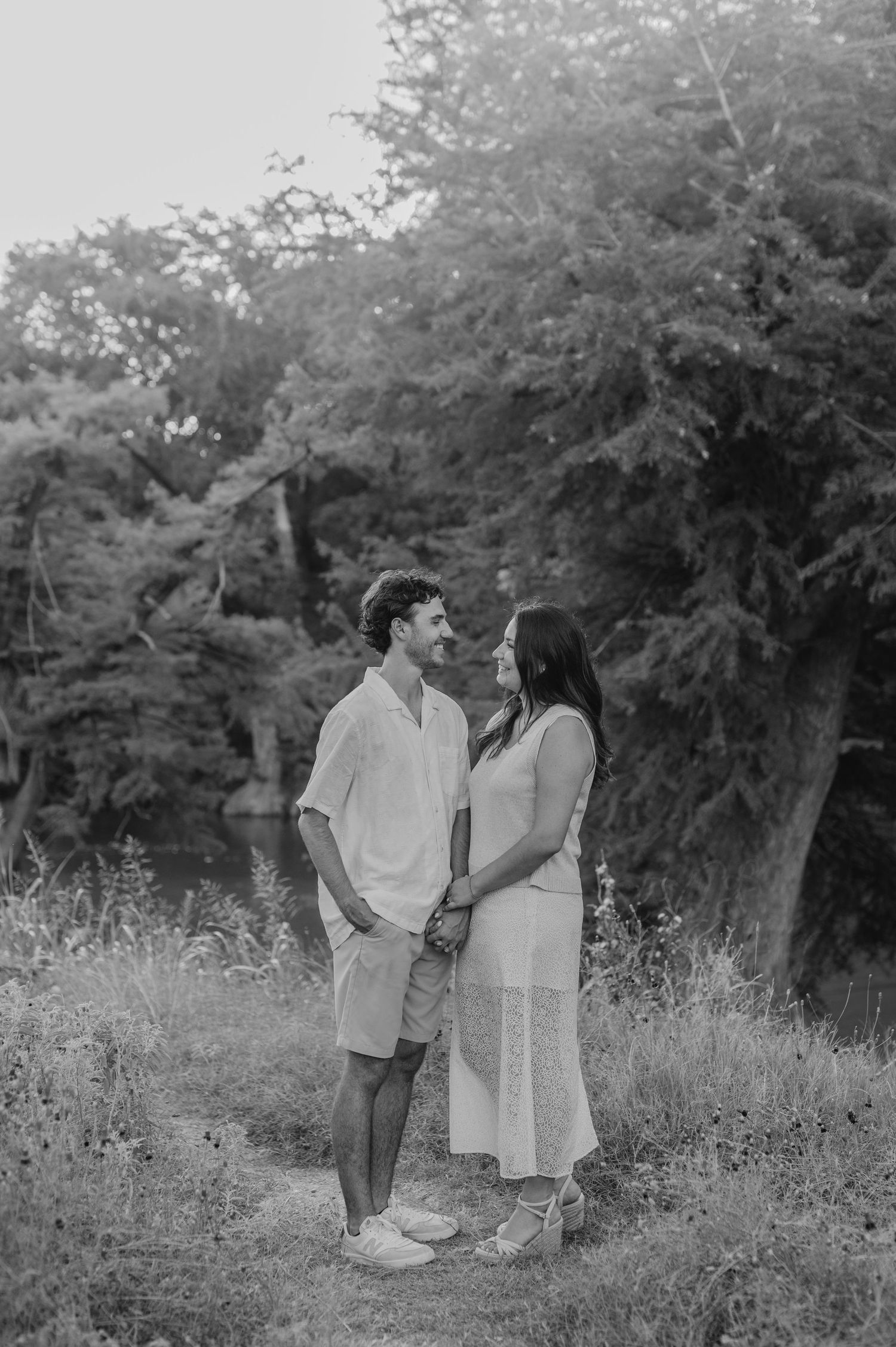 Black and white images showing tender moments between a couple in a wildflower field.