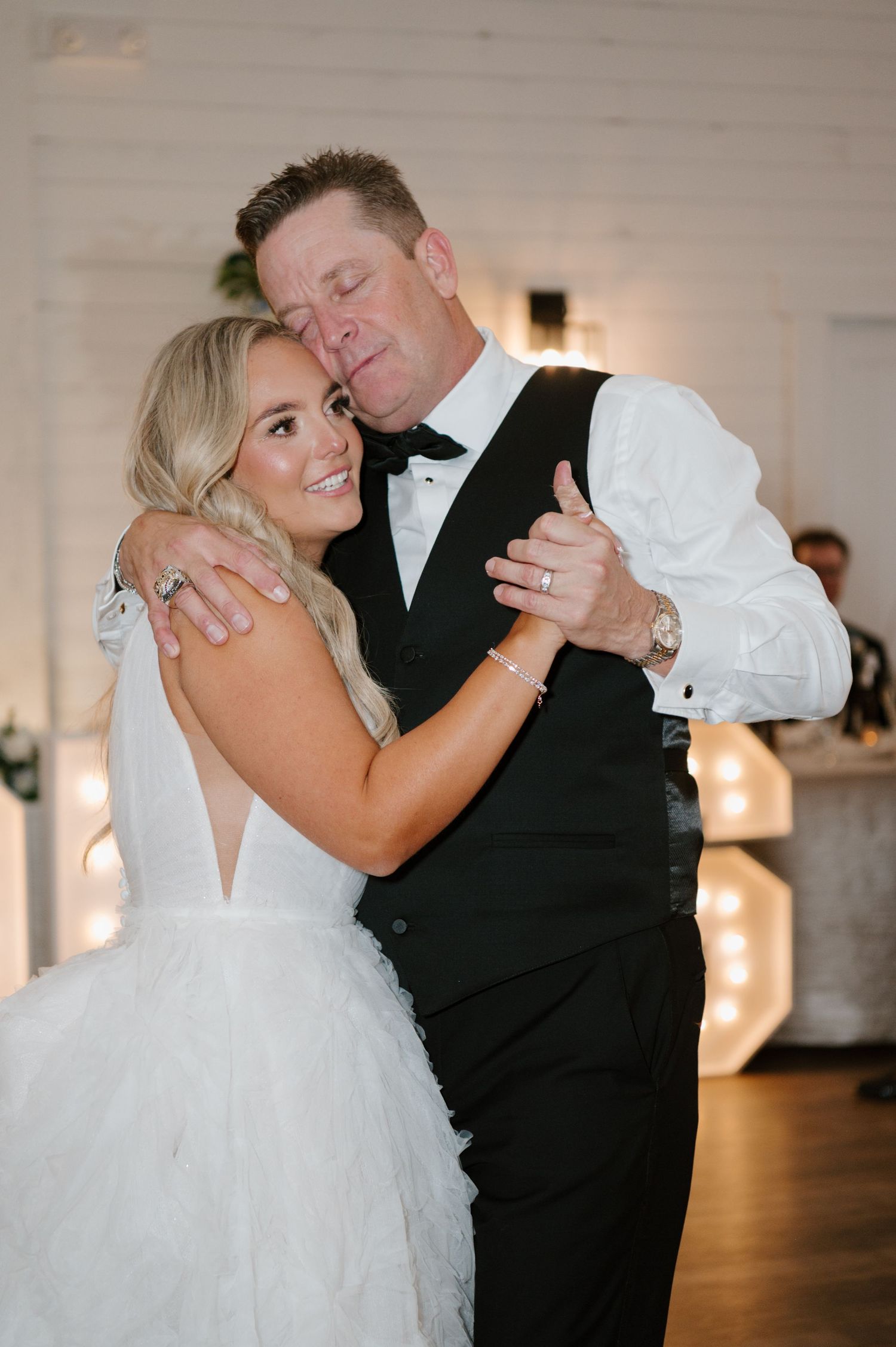 A bride and groom dancing together at their wedding reception.