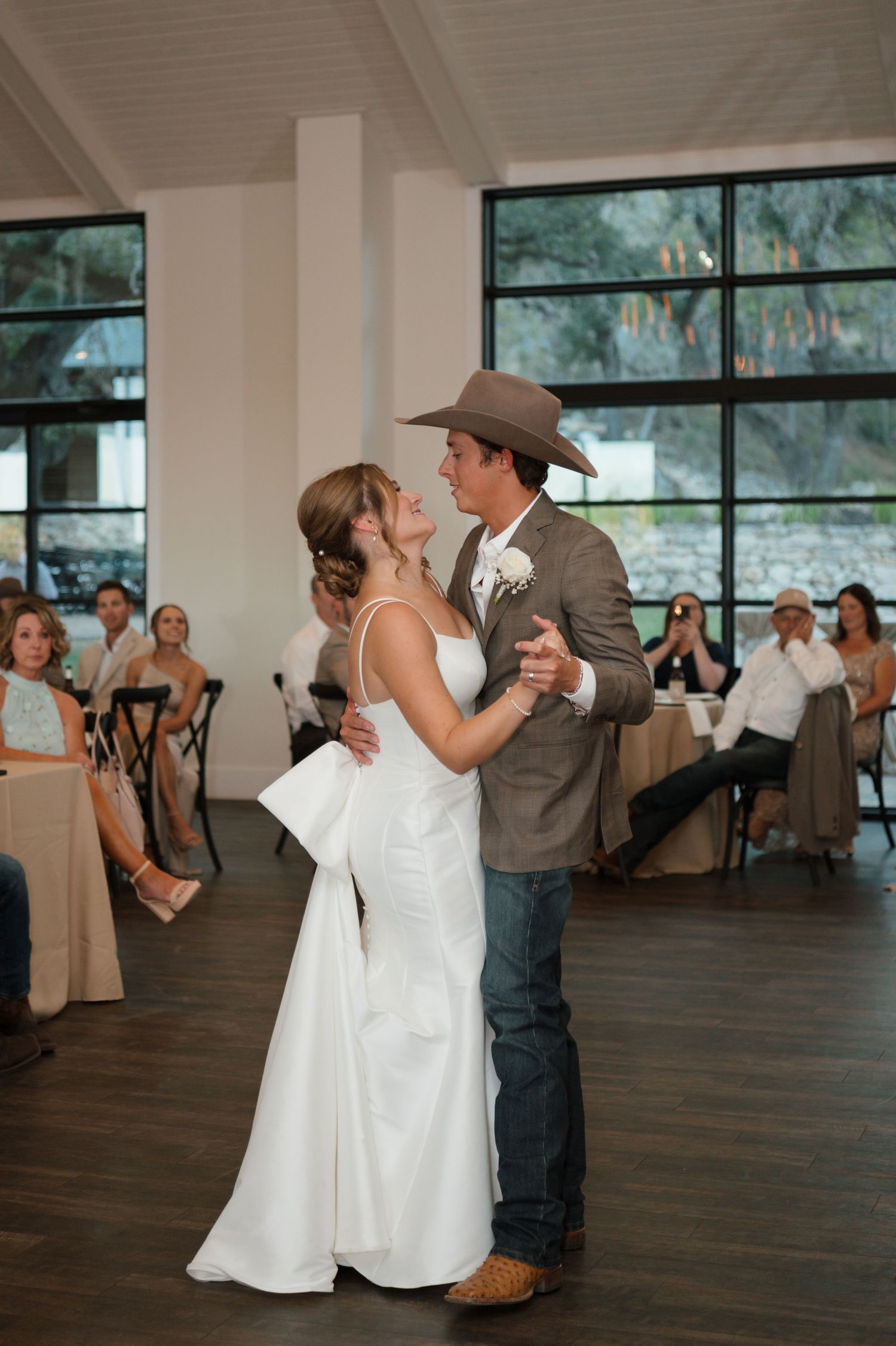 A couple shares their first dance at a rustic-themed wedding reception.