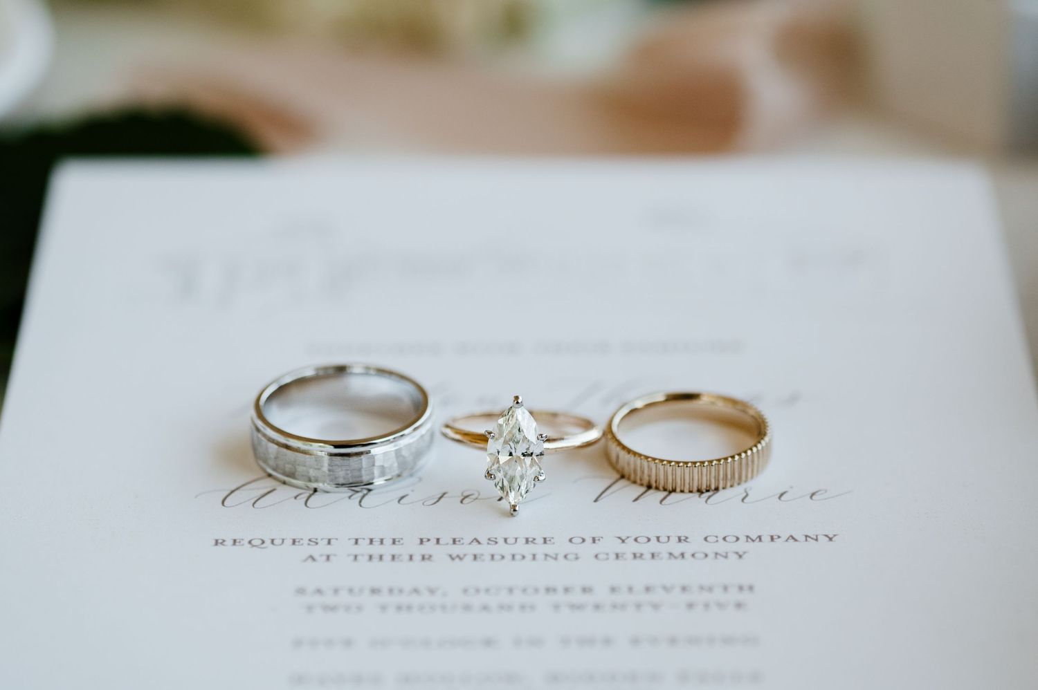 Three elegant wedding rings arranged on a white surface with delicate shadows and soft lighting.