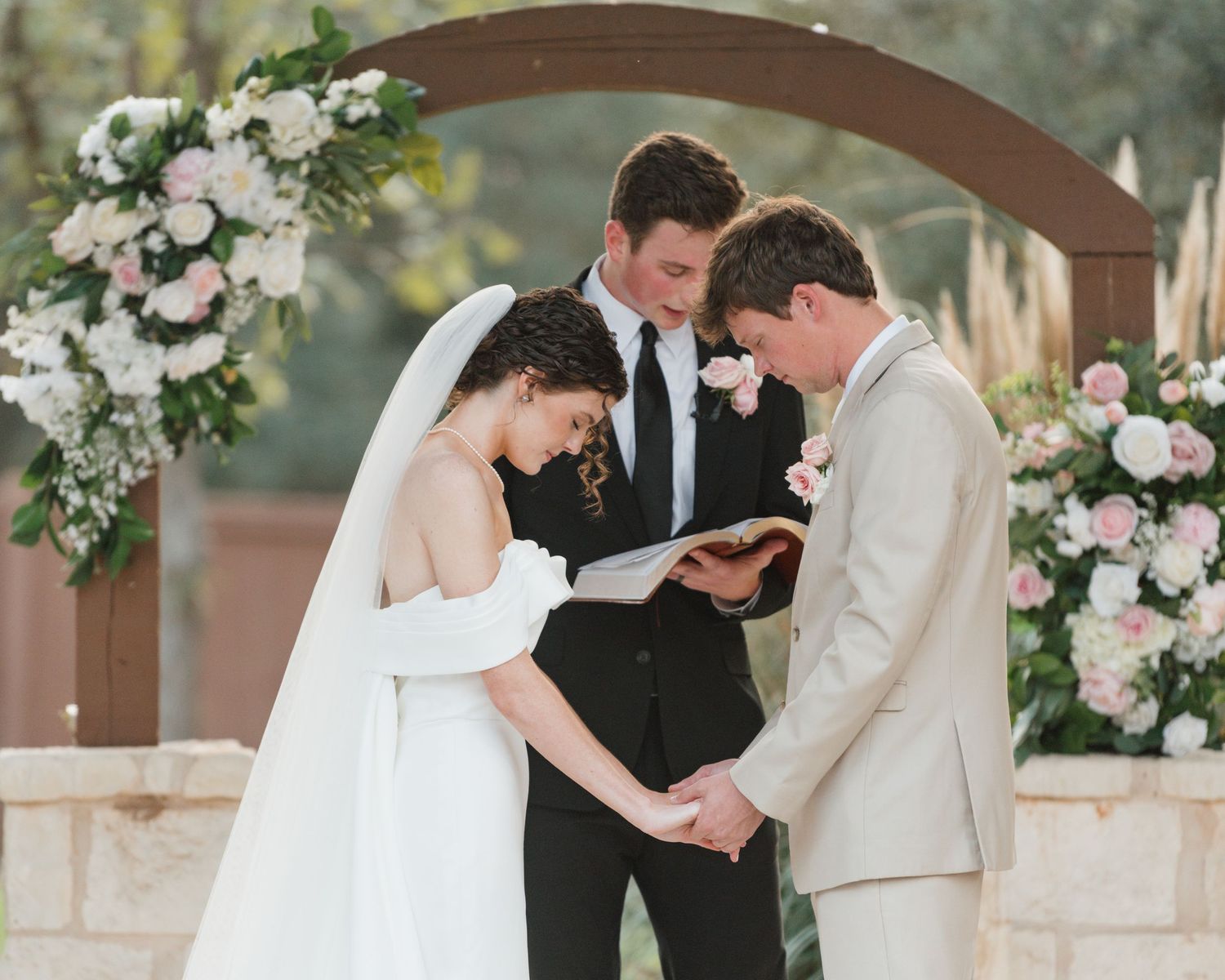 Series of romantic wedding ceremony moments captured under a wooden arch decorated with white and pink flowers.