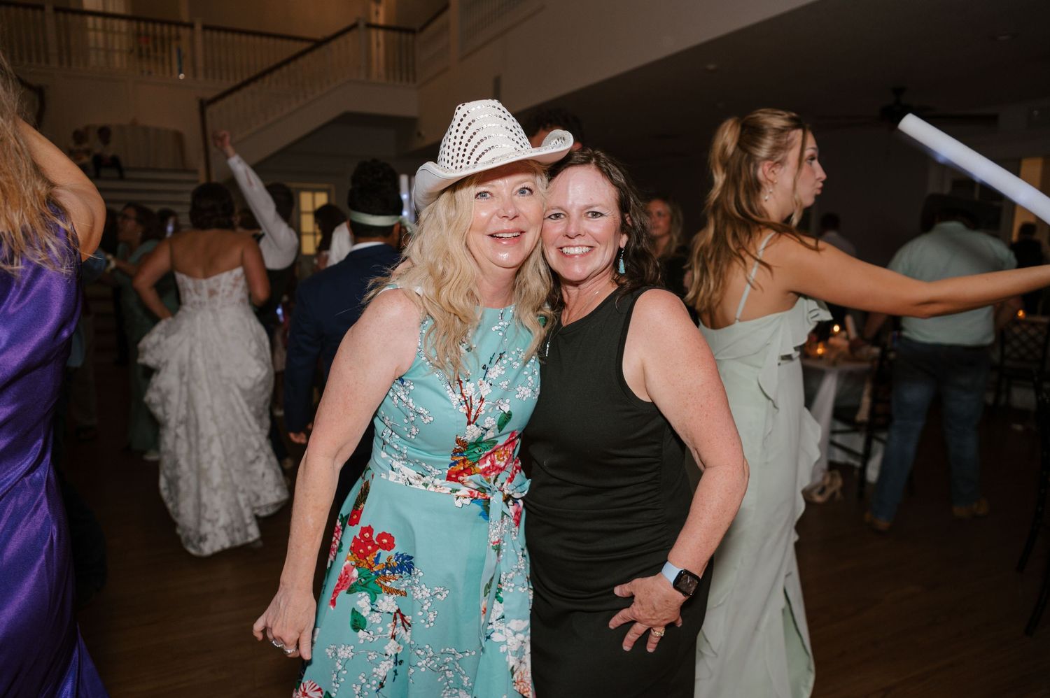 Guests dancing and celebrating on the dance floor at a wedding reception.
