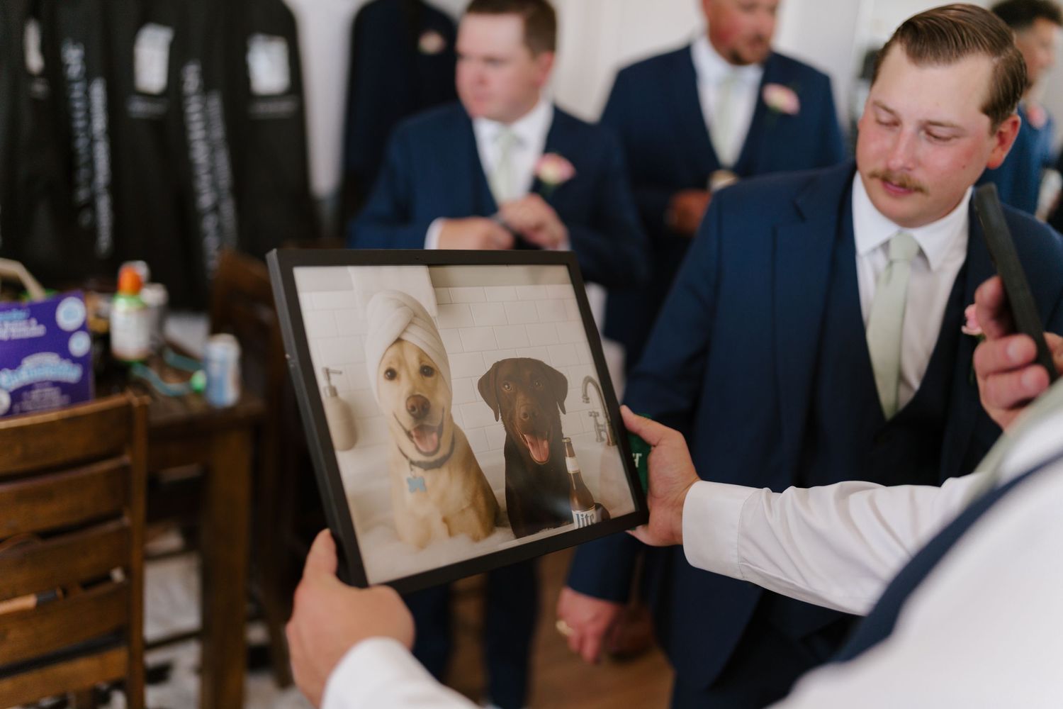 Groomsmen in navy suits react with excitement during wedding festivities.