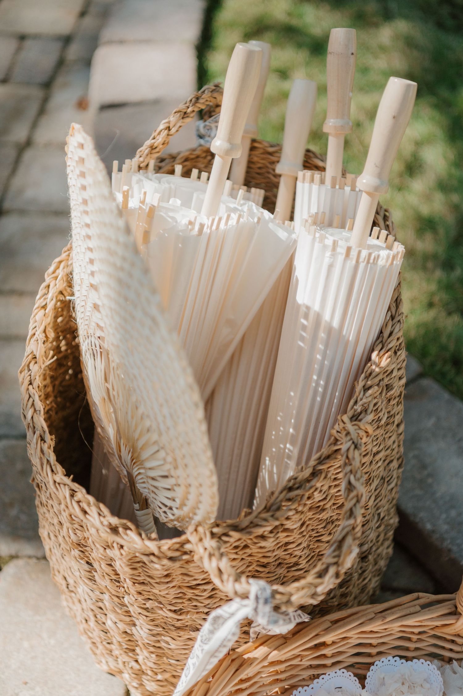 White drinking straws arranged in a woven basket for an elegant wedding reception setup.