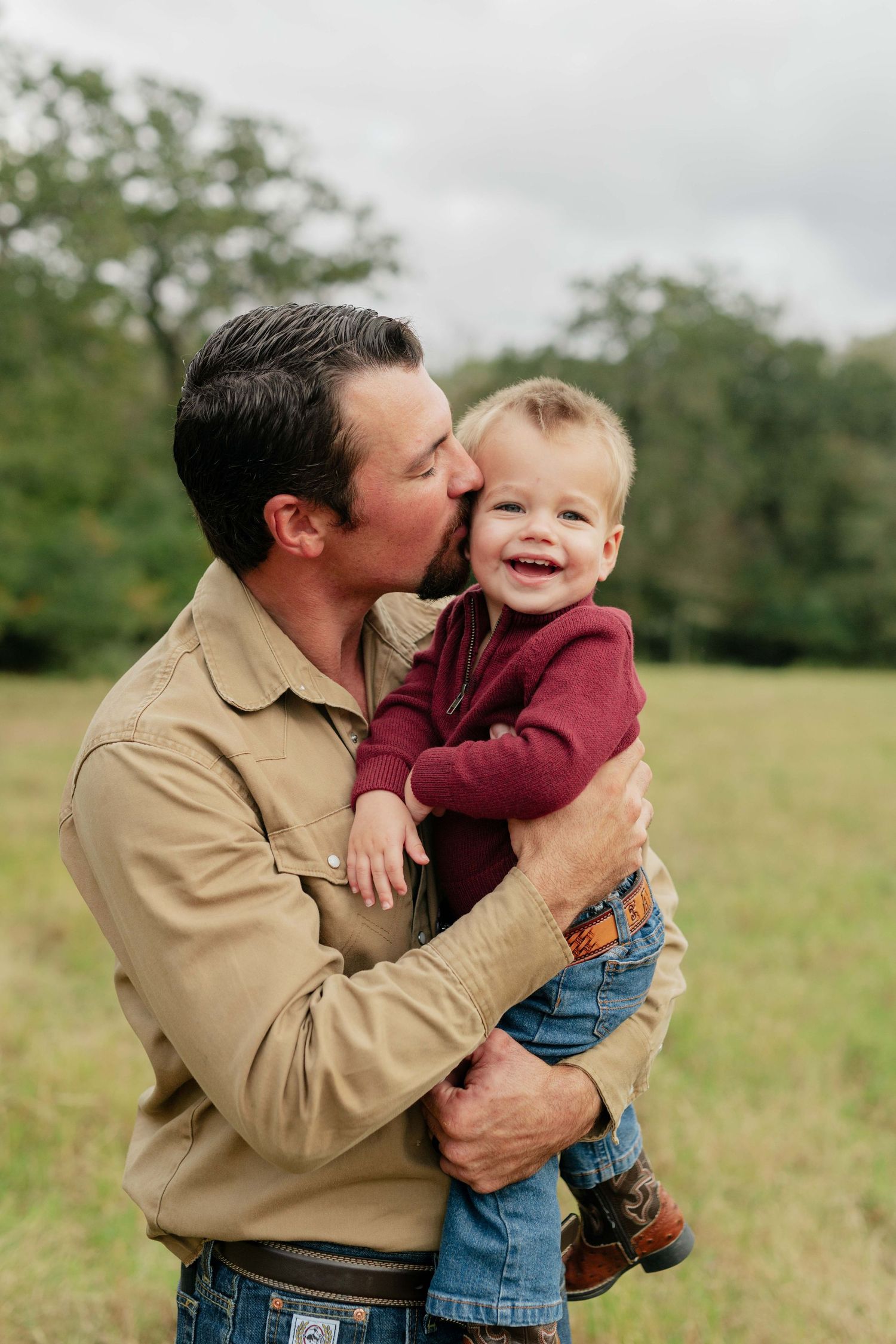 A tender moment between parent and child in a sunlit field.