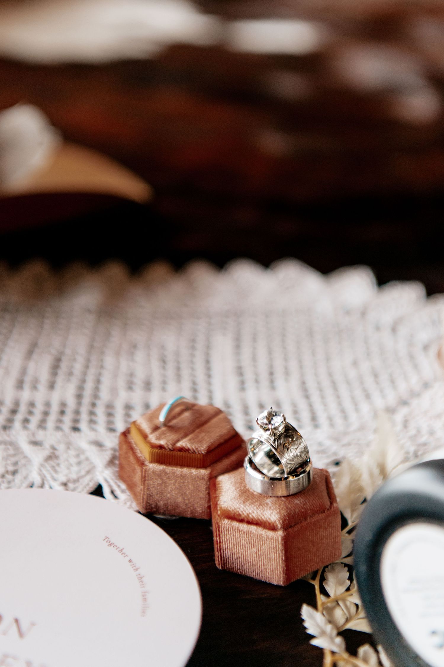 Close-up of two rose gold wedding rings on a delicate lace doily.