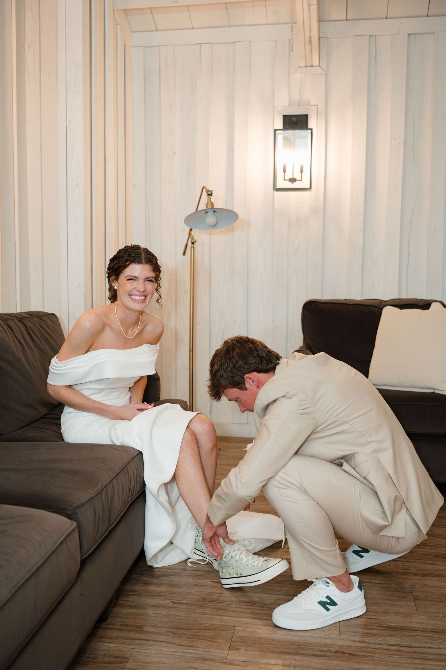 A person in white sits on a couch while someone in beige bends down to tie their shoes in a series of photos.