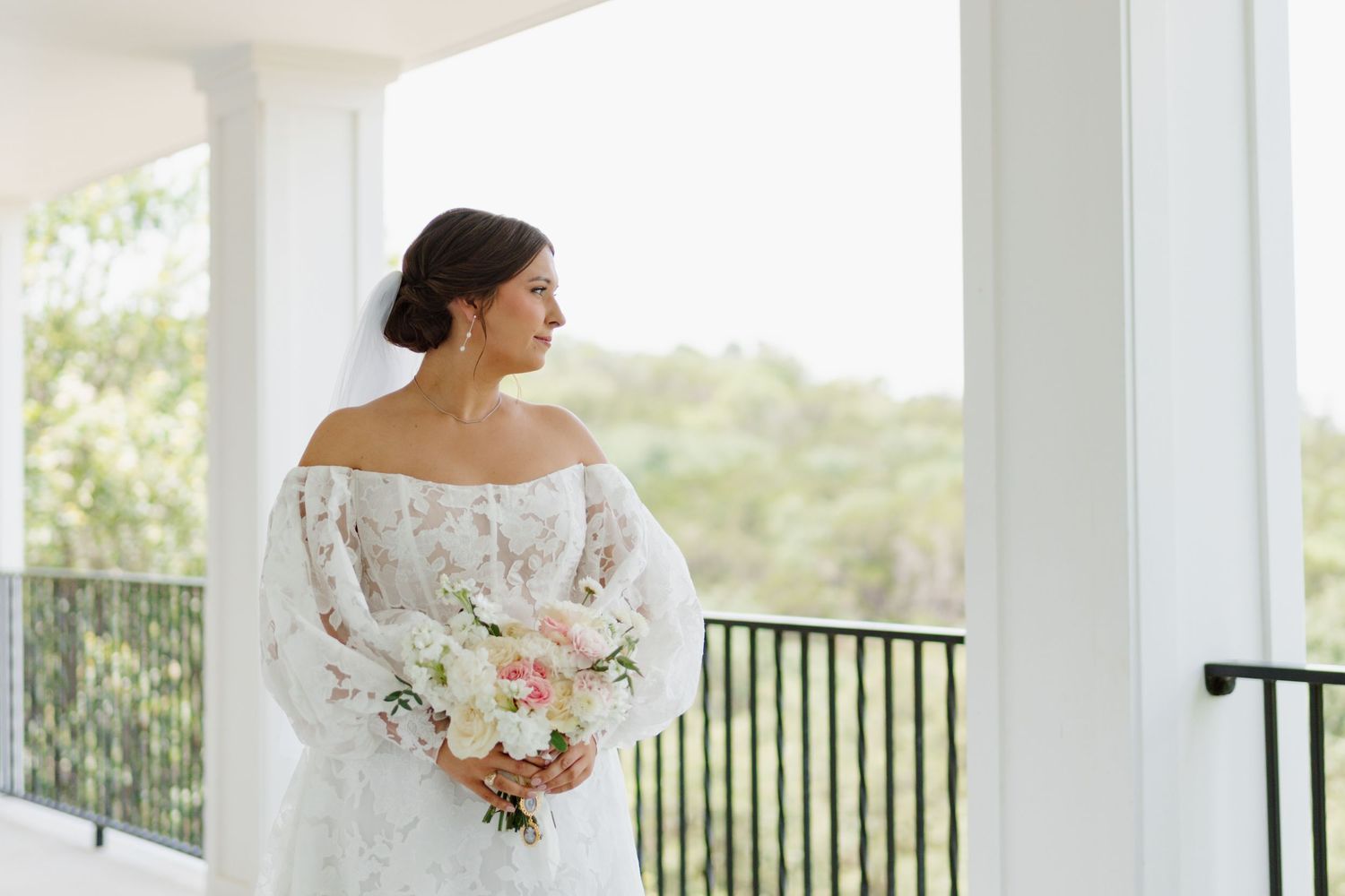 Elegant wedding photos captured on a bright white porch with black railings and natural lighting.