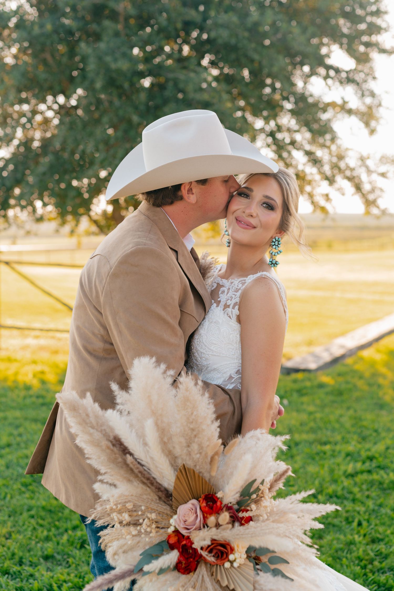 Romantic wedding portrait with pampas grass bouquet in golden sunset light.