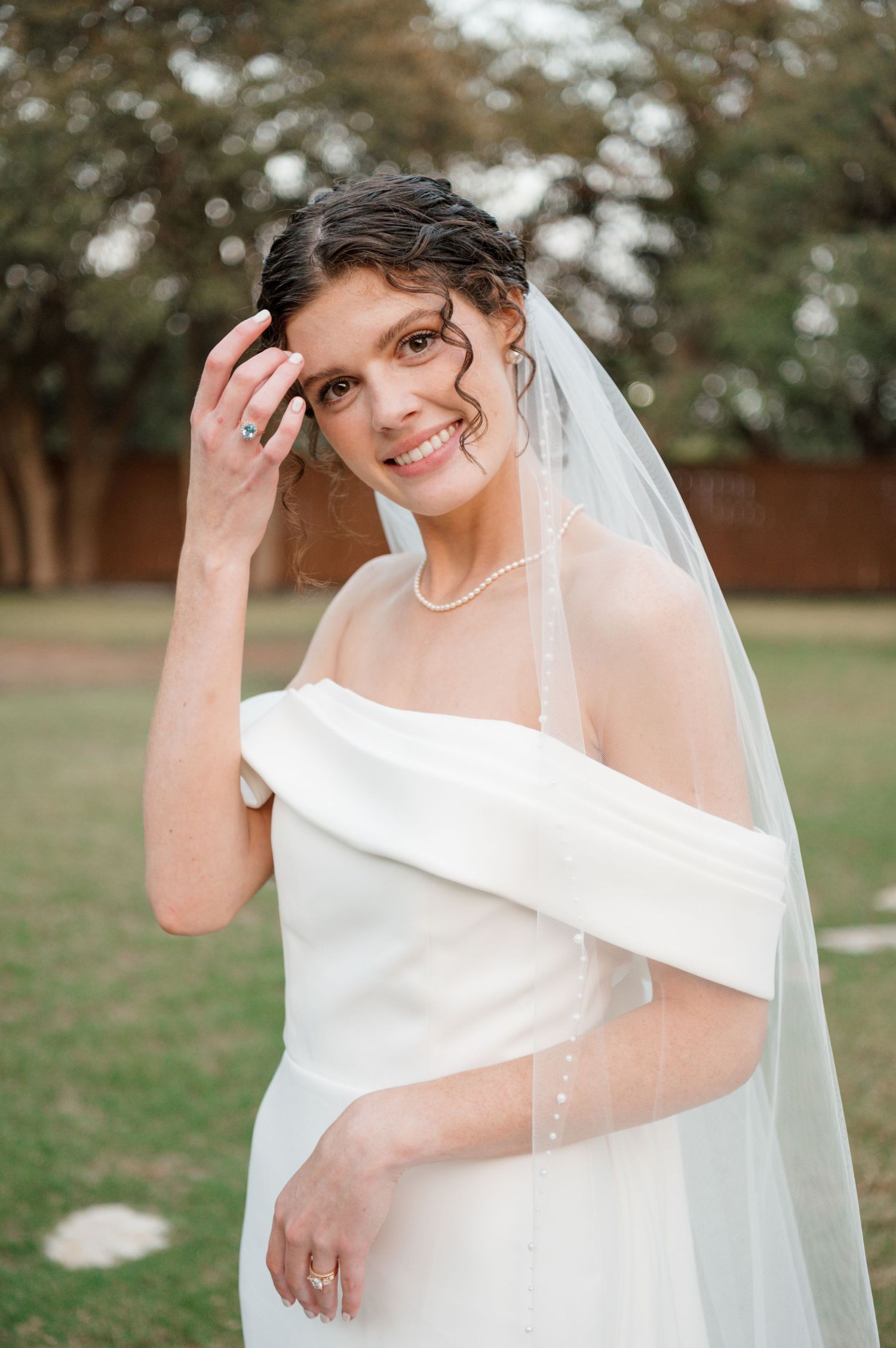 Close-up portrait shots of bride in white dress and veil against outdoor backdrop.