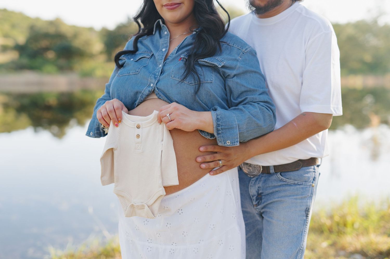 A couple shares an intimate moment in matching denim and white outfits during a sunset photo session.