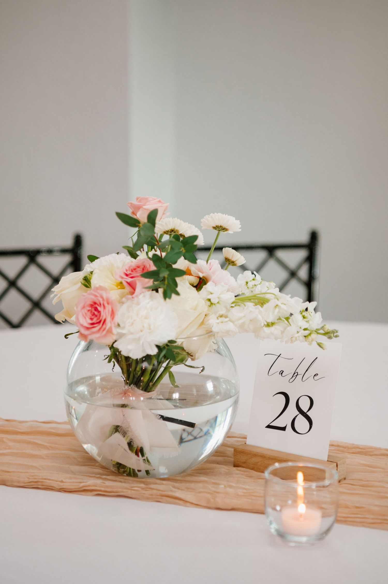 Wedding reception table decor with pink roses and table number 28.