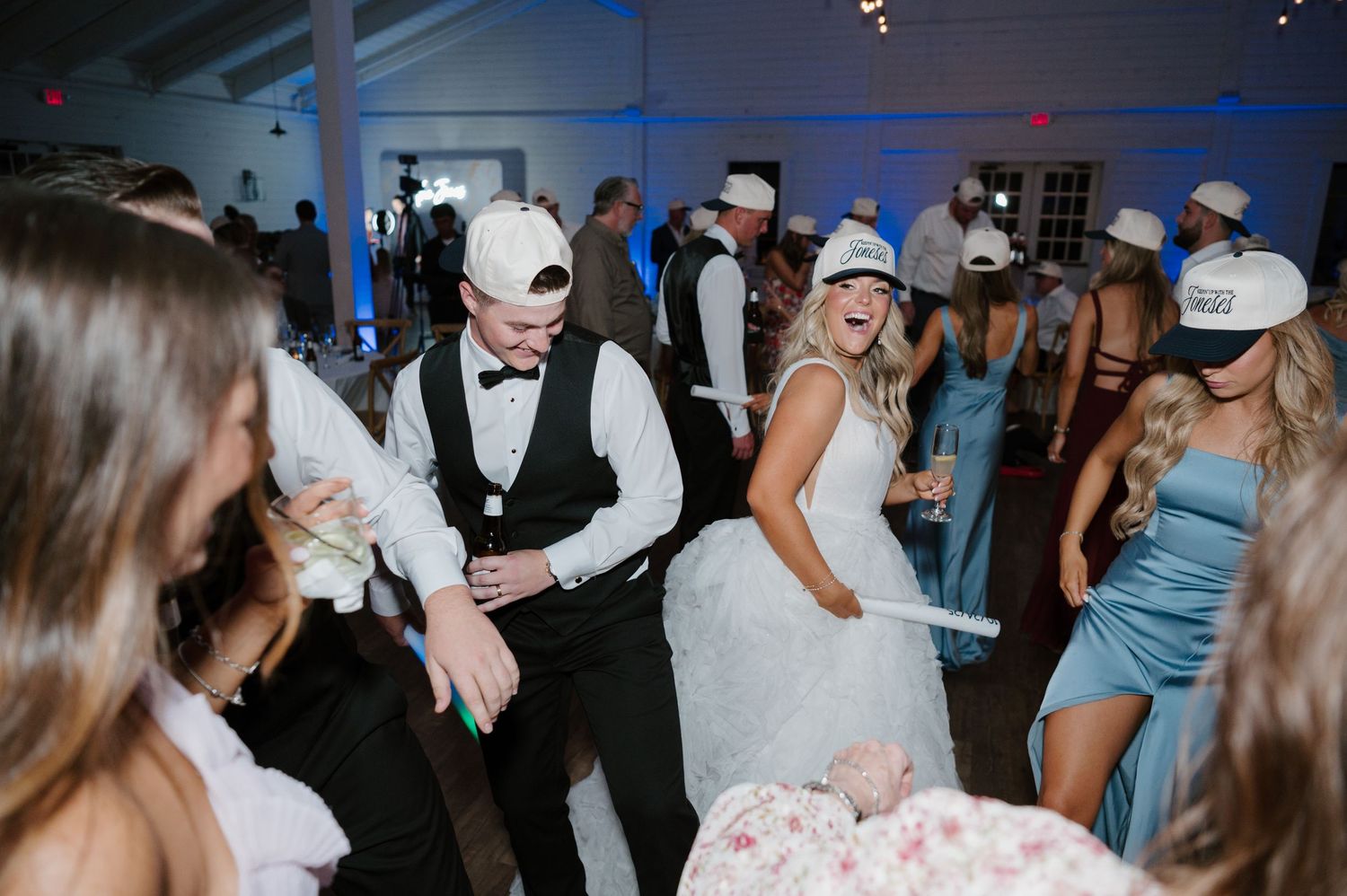 A wedding reception with a bride and groom dancing with guests in formal attire.