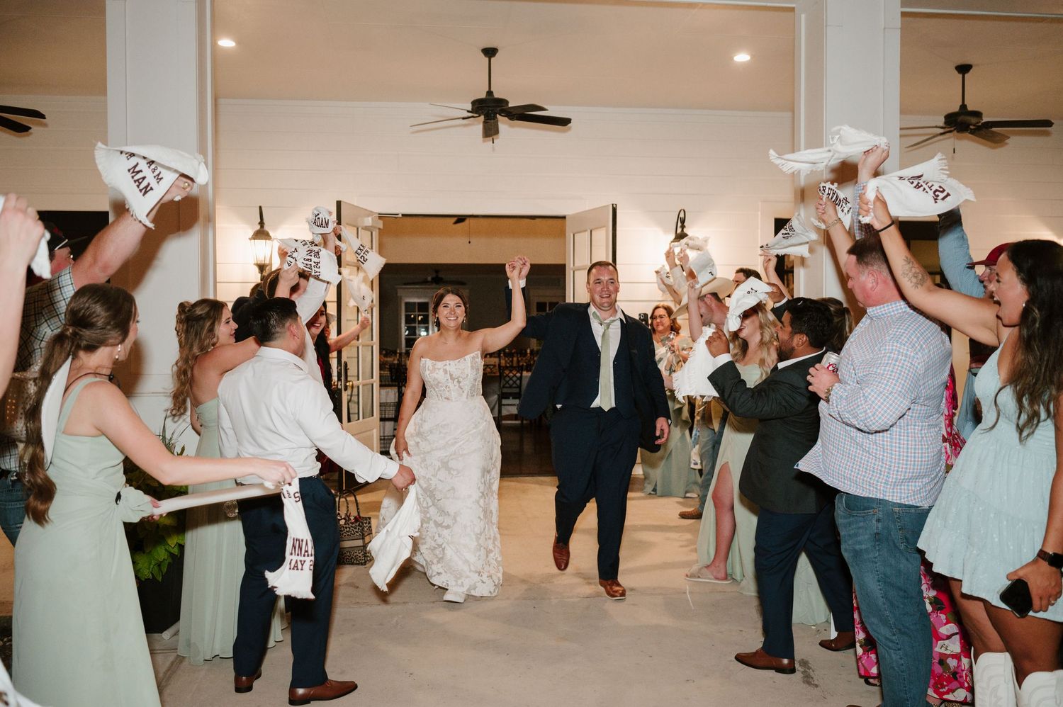 Wedding reception guests dancing and enjoying themselves on wooden dance floor.
