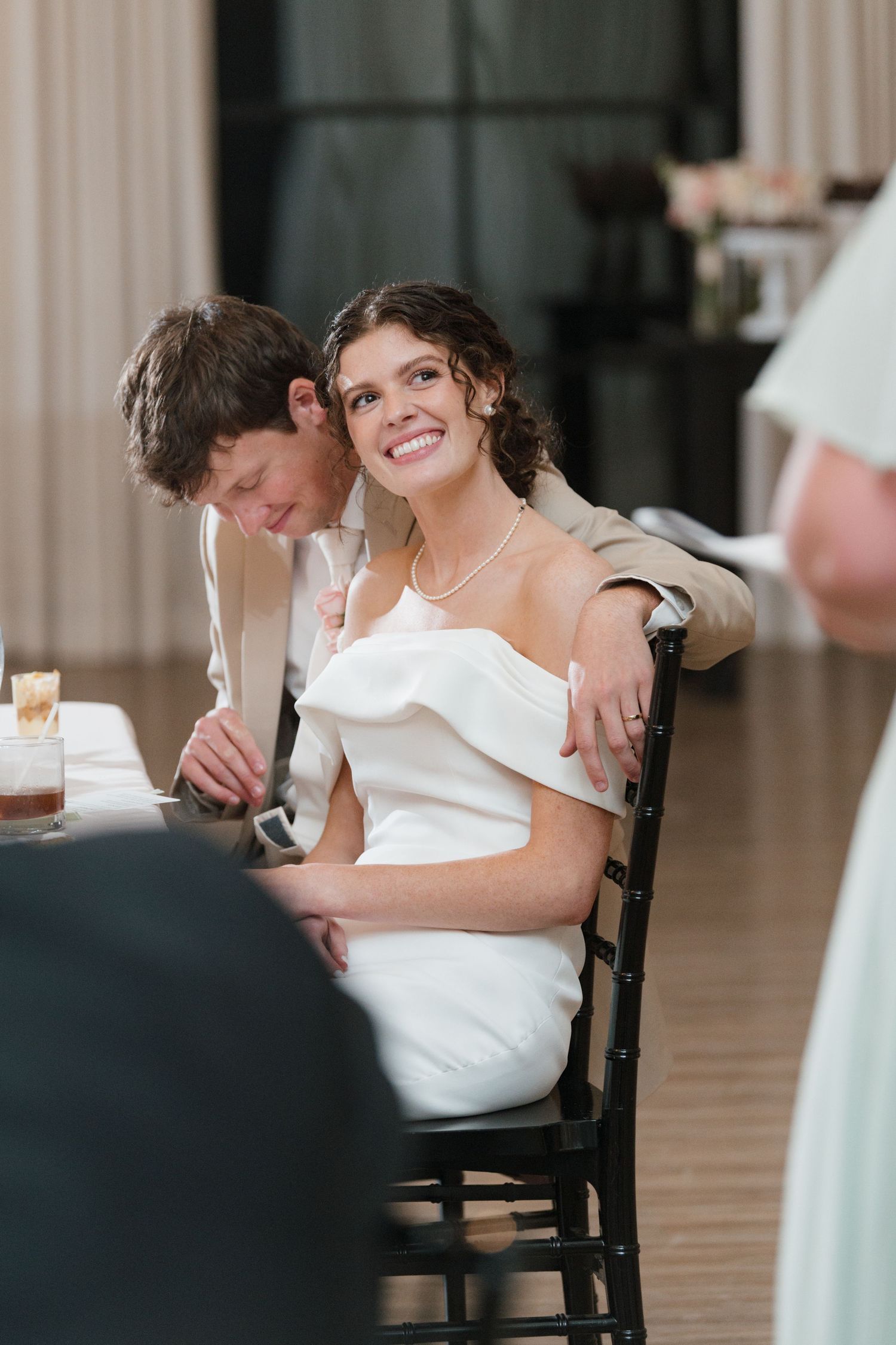 Candid wedding reception moments captured during speeches and toasts in an elegant indoor venue.