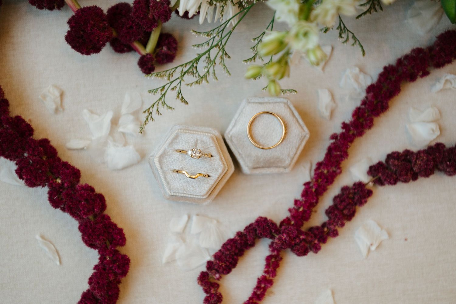 Elegant floral arrangement with deep burgundy amaranth and delicate white roses on a light background.
