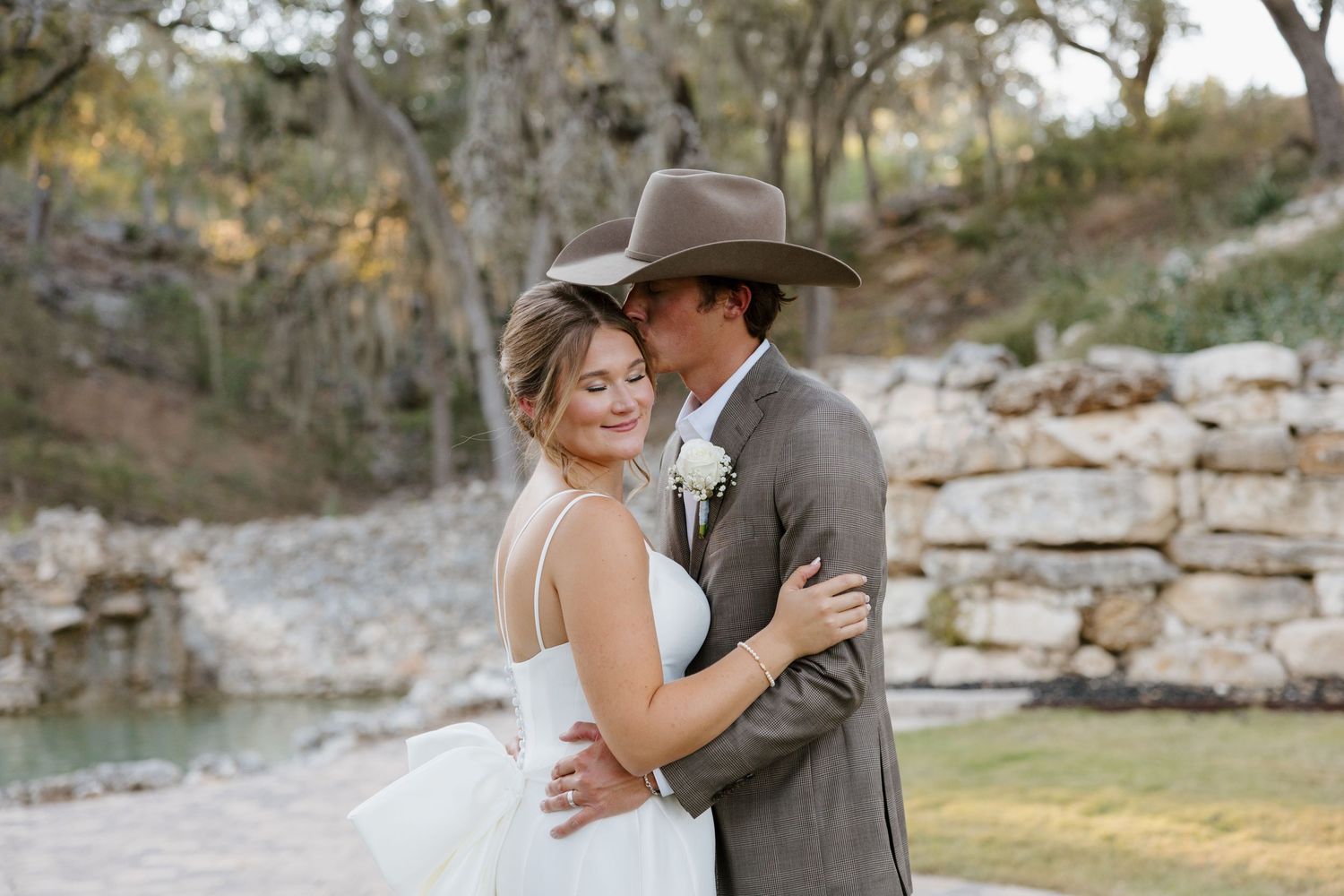 A couple poses for their bridal portraits in front of a stone wall at Hidden Falls Hayes Hollow. Photographed by Alyssa Denson Photography.