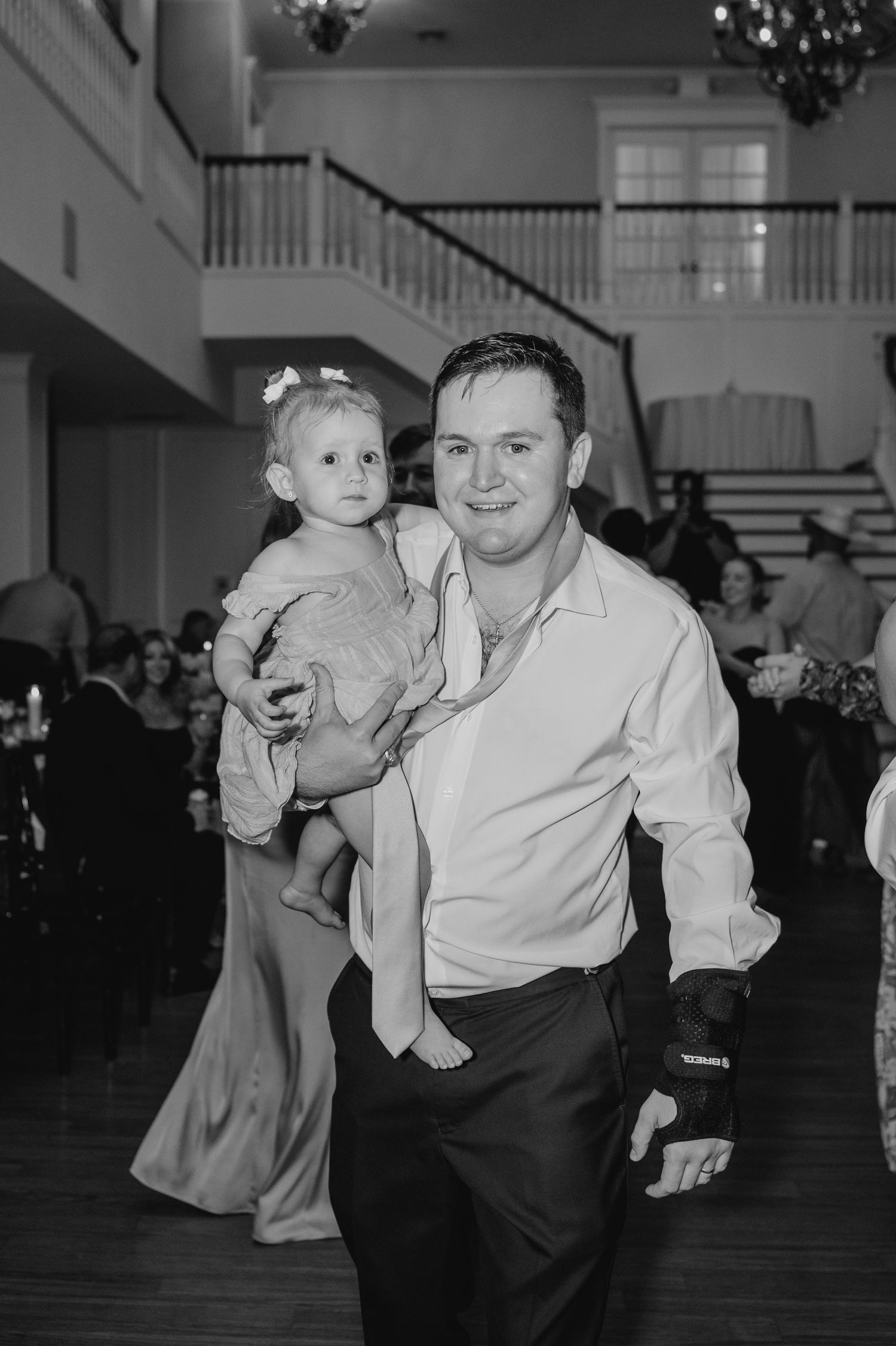 Black and white candid photo of a joyful dance moment at a reception party.