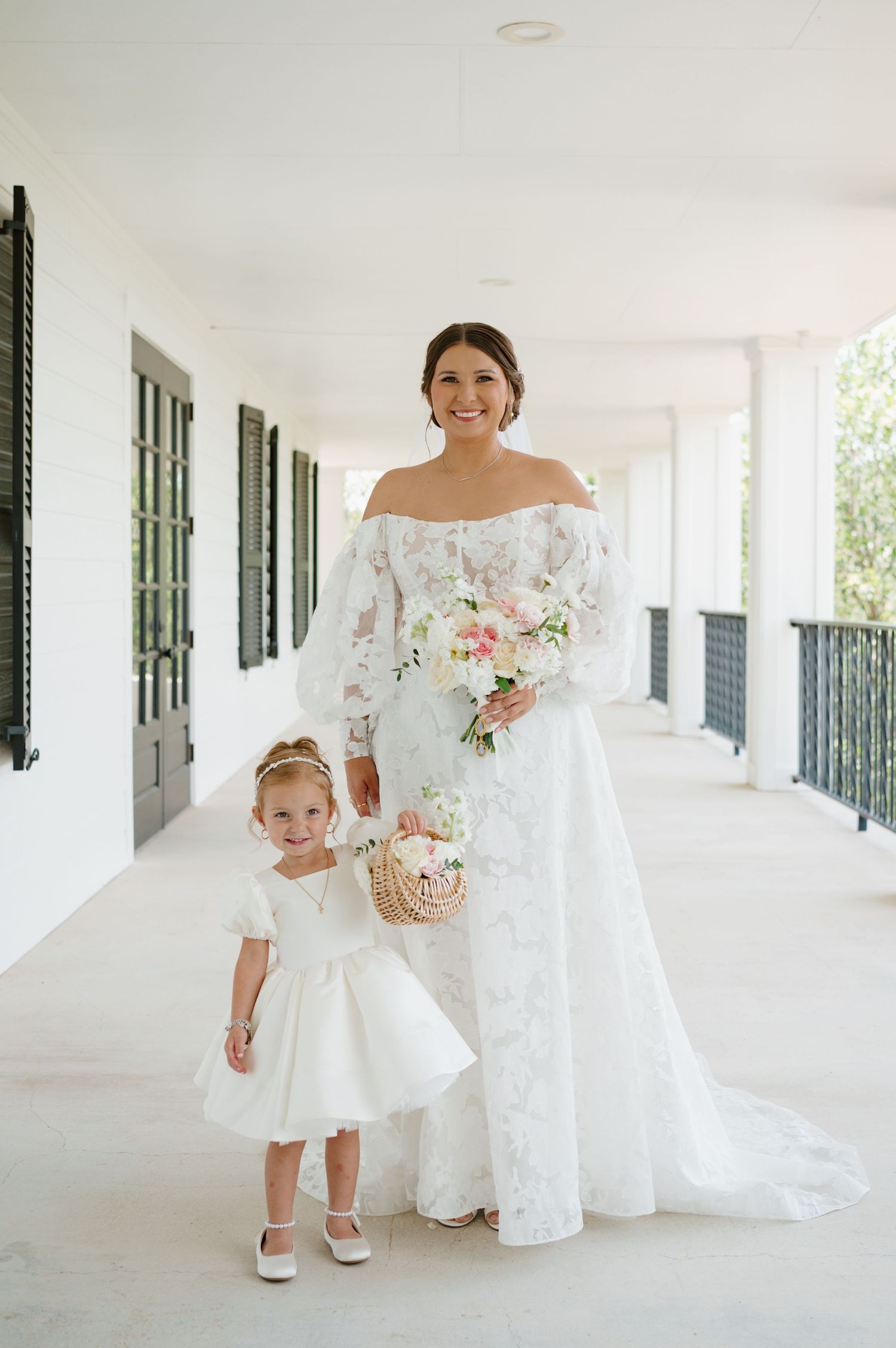 A beautiful white wedding dress flows gracefully along a bright covered porch.