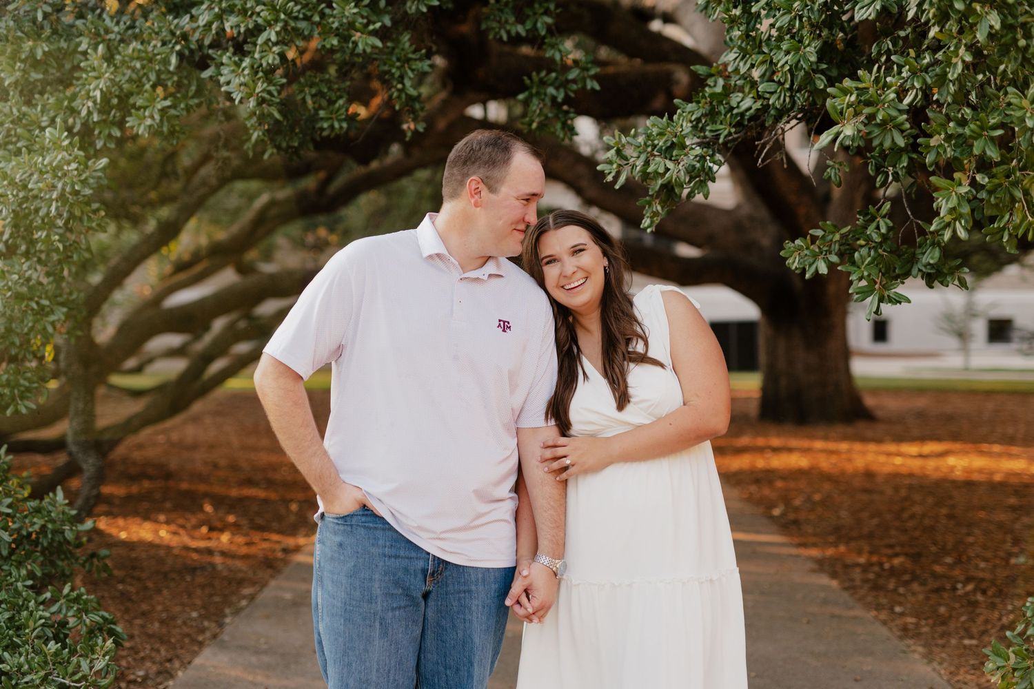 A sweet moment captured beneath sprawling oak trees on a fall afternoon.