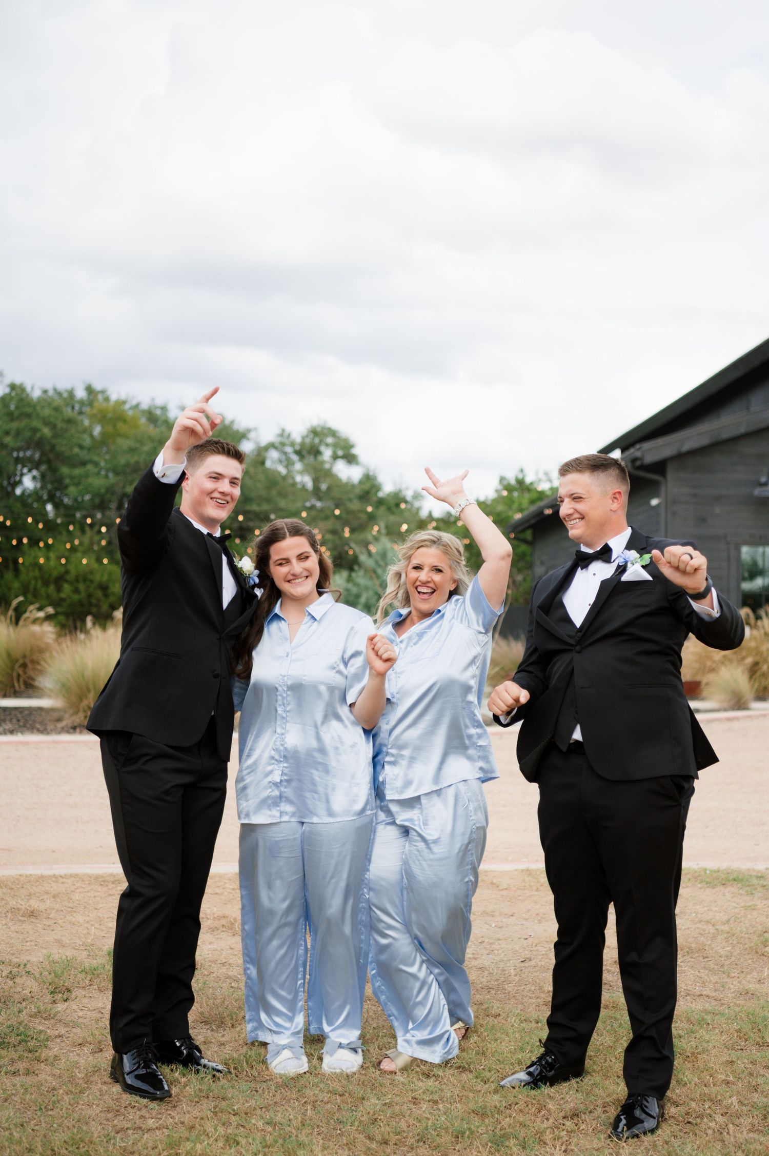 A group of people in formal wear celebrating and jumping in the air.