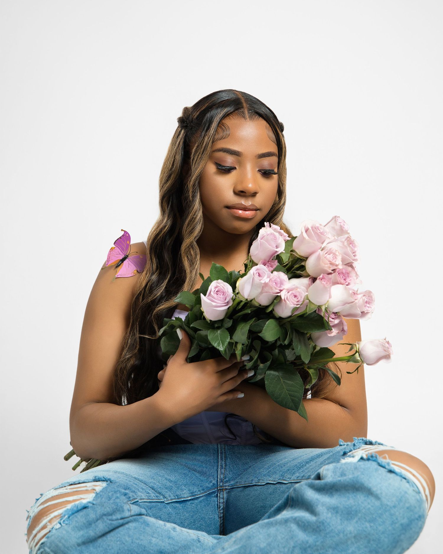 Serene portrait with pink roses and distressed denim in studio setting.