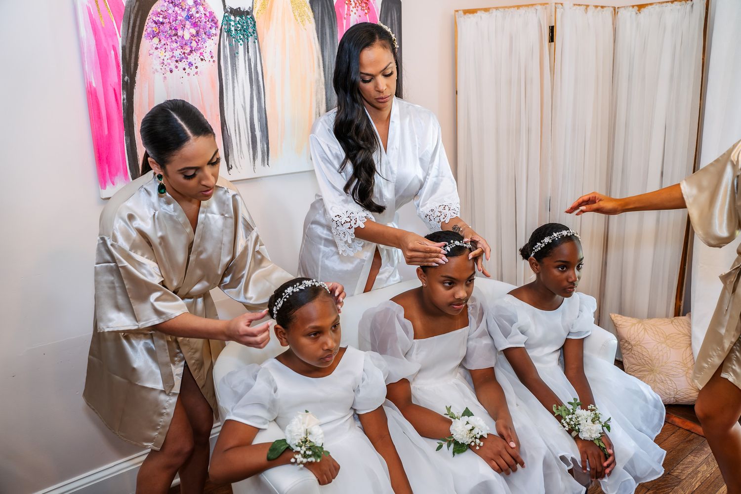 A group wearing matching white robes during wedding preparations.