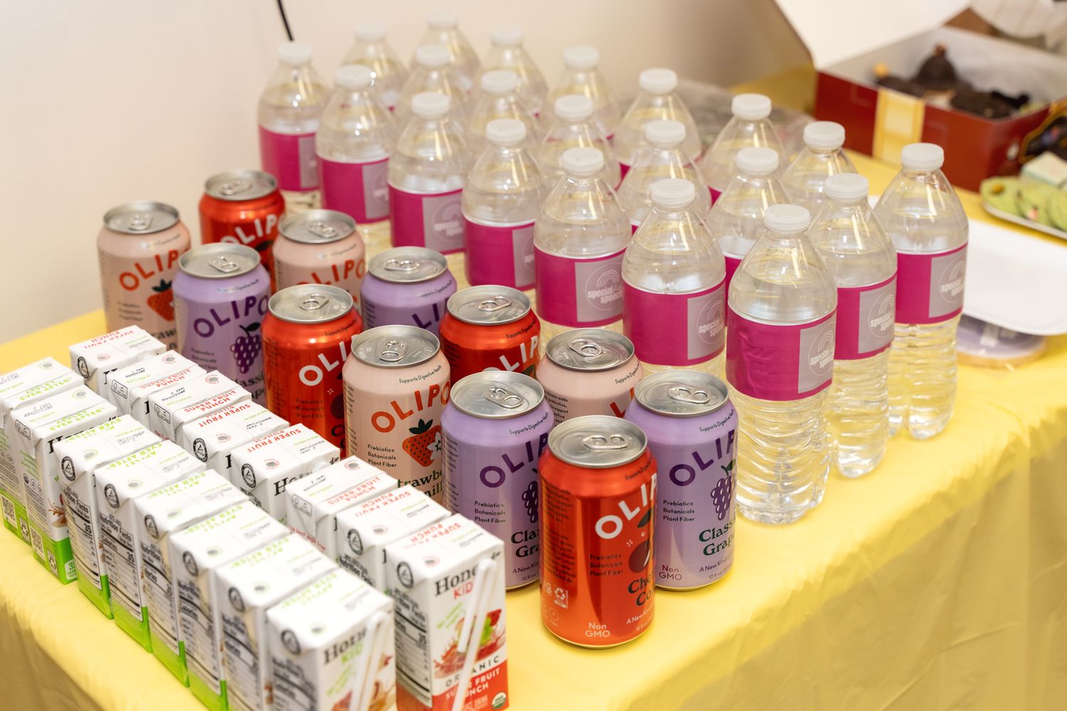 A table display of drinks and refreshments with pink and purple color scheme.
