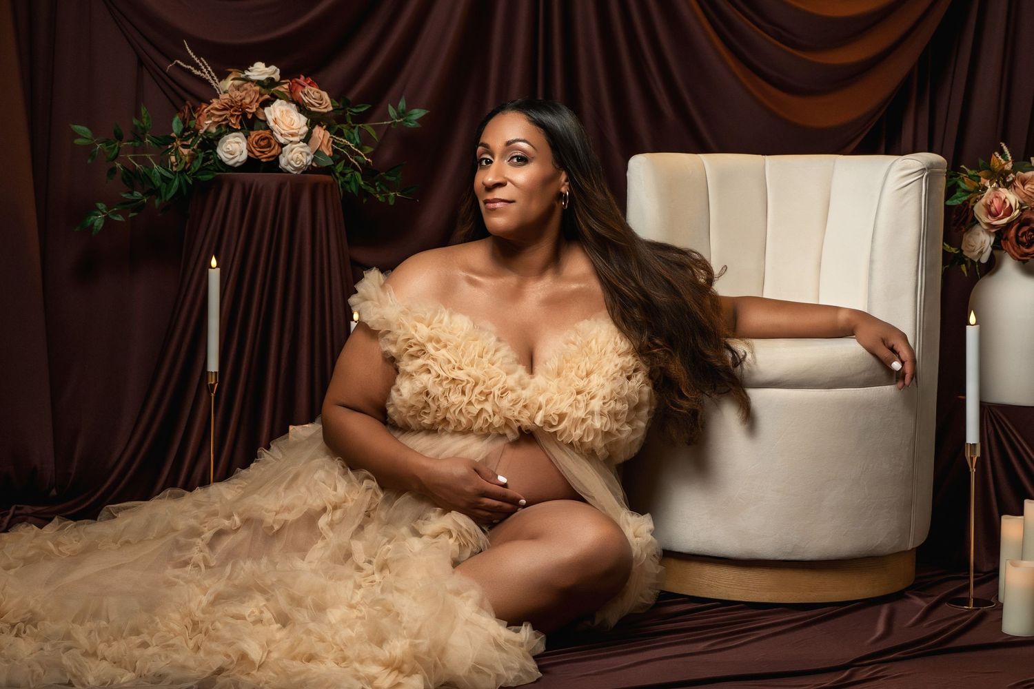Elegant boudoir photography setup with draped fabric and floral decorations.
