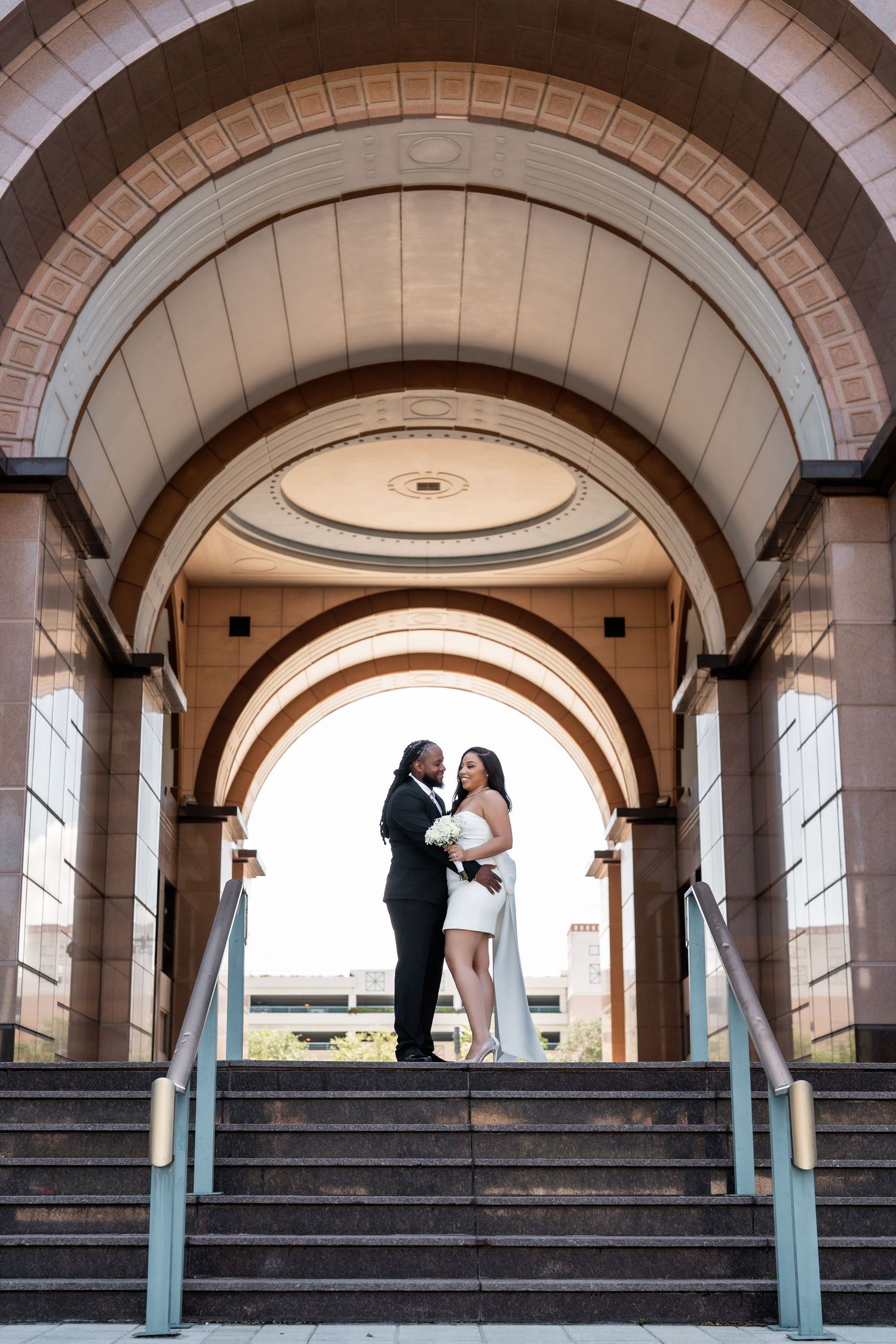 Romantic wedding photos captured under elegant stone archways with classic architecture.