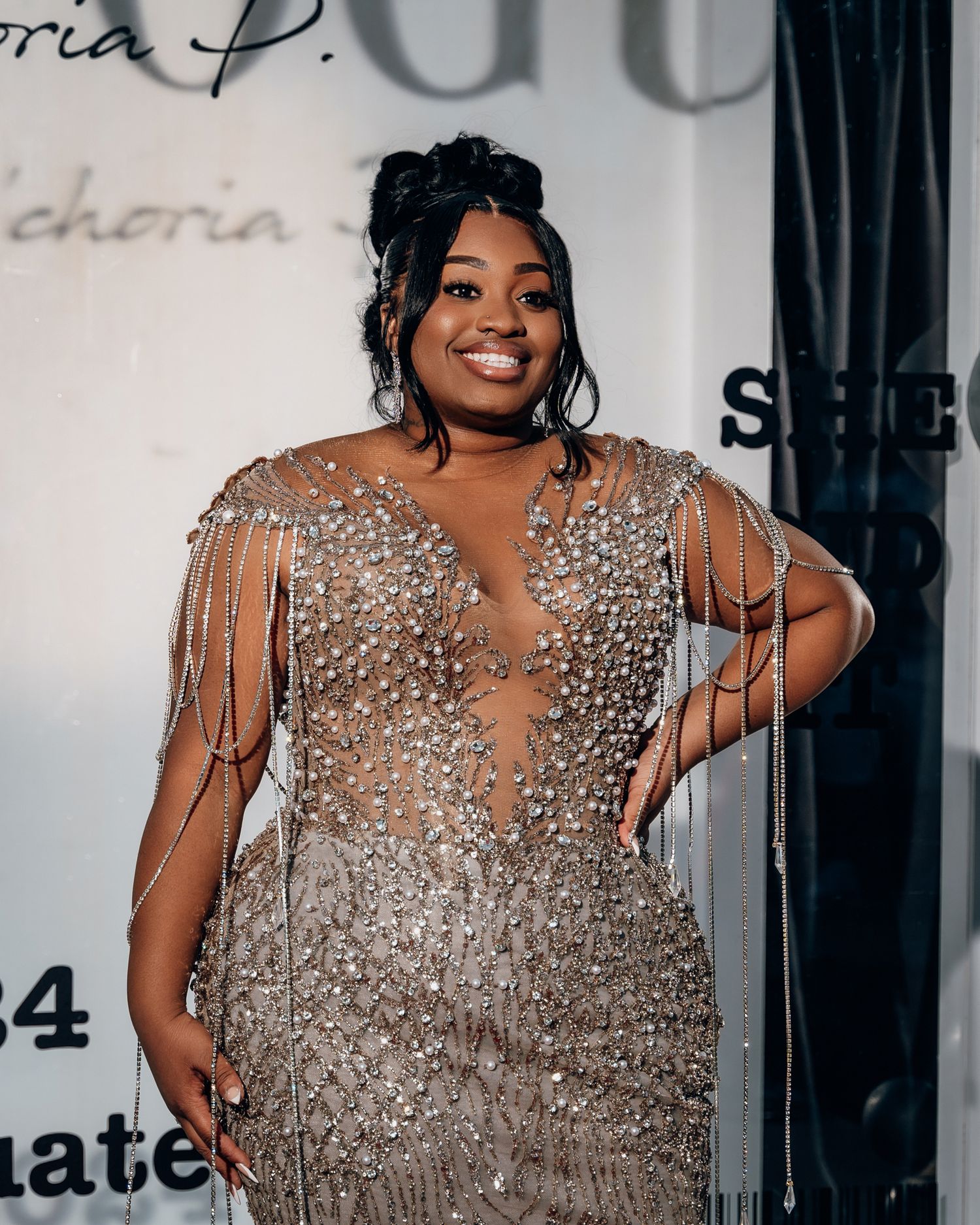 An elegant plus-size formal dress with sheer beaded details and draped crystal embellishments.