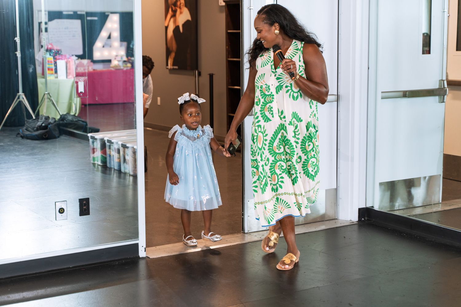 A colorful green and white floral dress adds brightness to the modern indoor space.