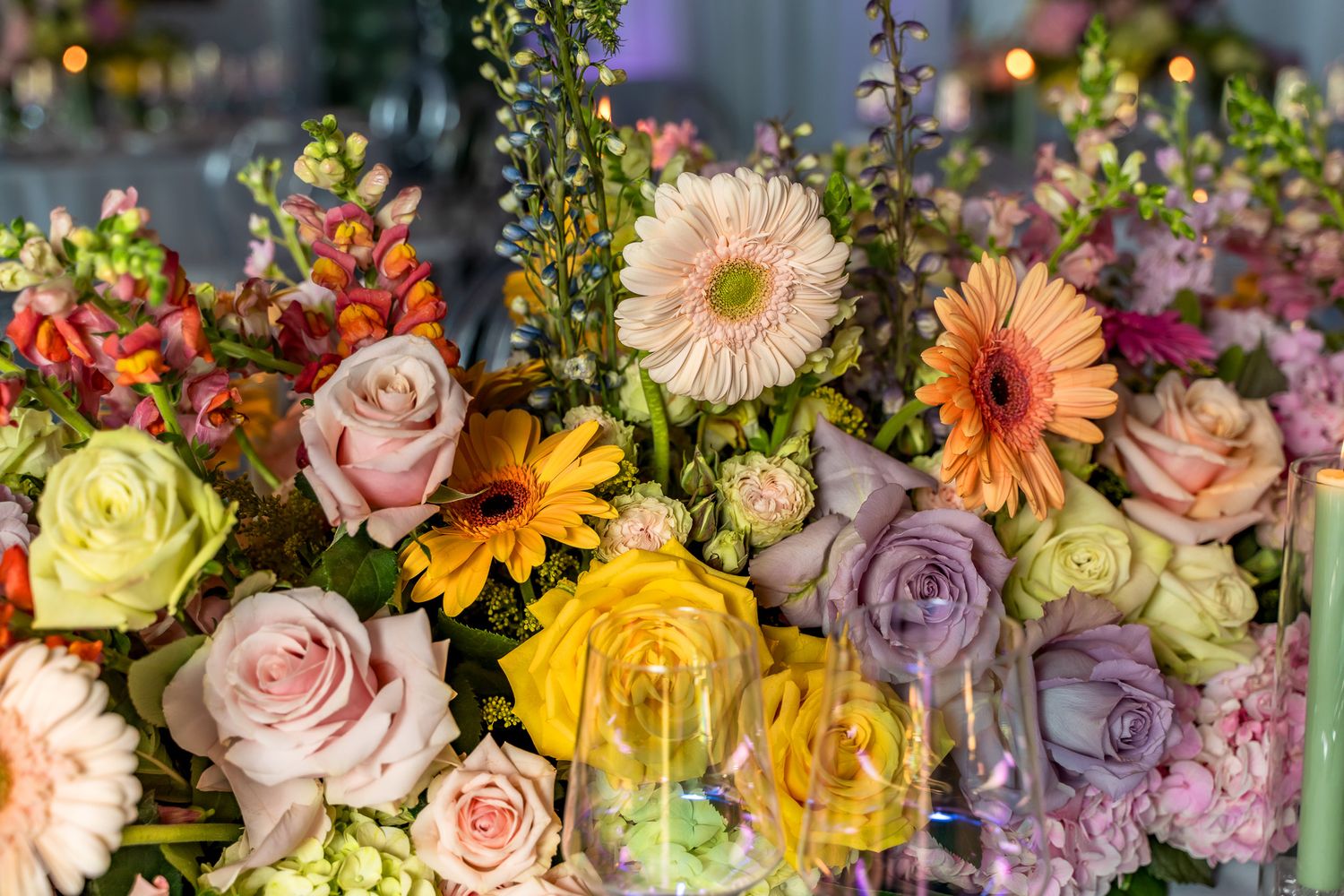 Vibrant floral arrangement featuring colorful roses, gerbera daisies, and mixed blooms in pastel hues.