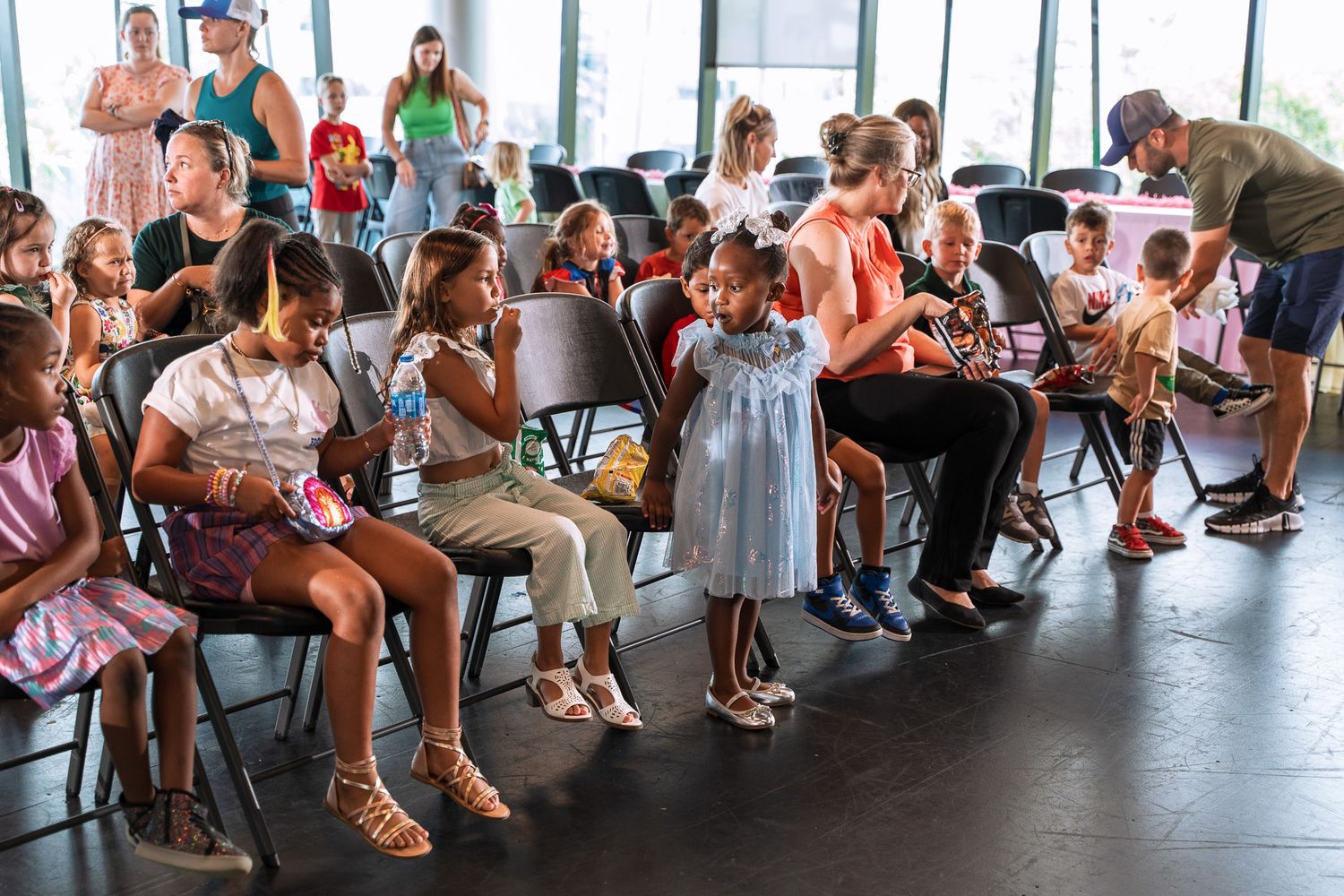 People seated in rows watching a performance or presentation in a modern studio space.