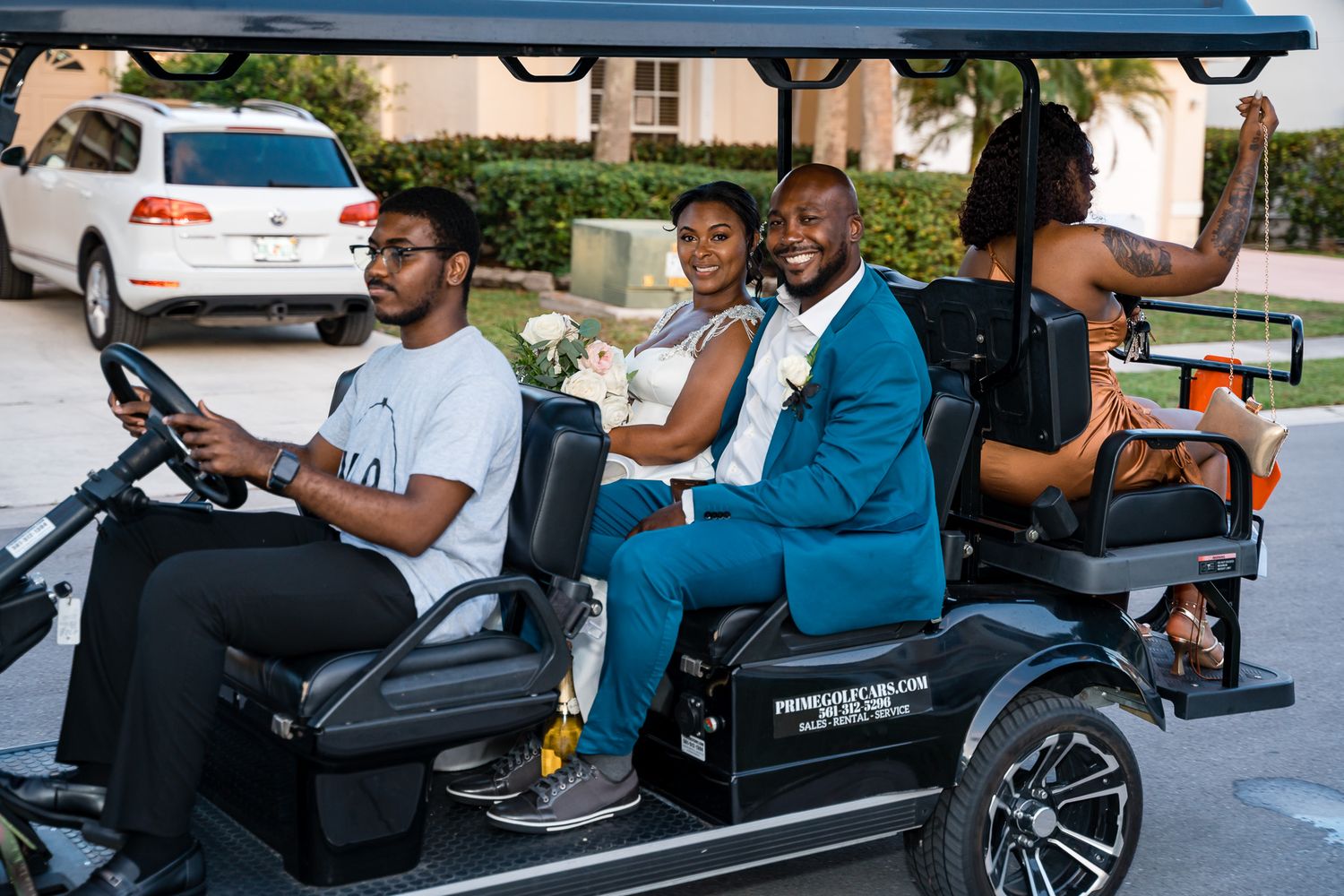 Wedding party riding in a luxury golf cart wearing formal attire.