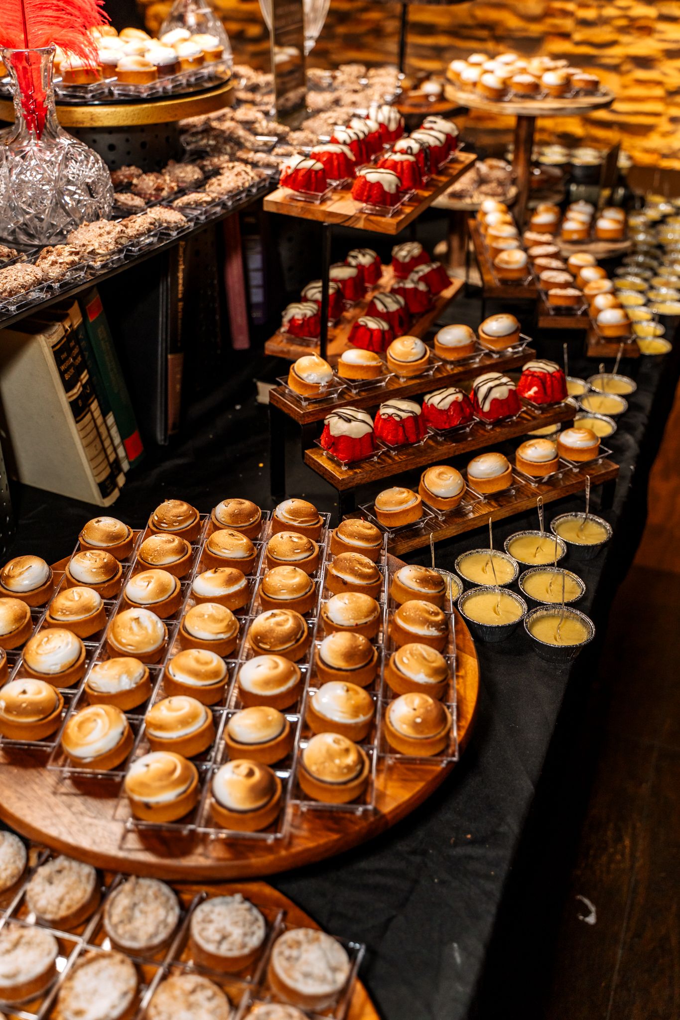 Elegant display of miniature desserts arranged on tiered wooden platters.
