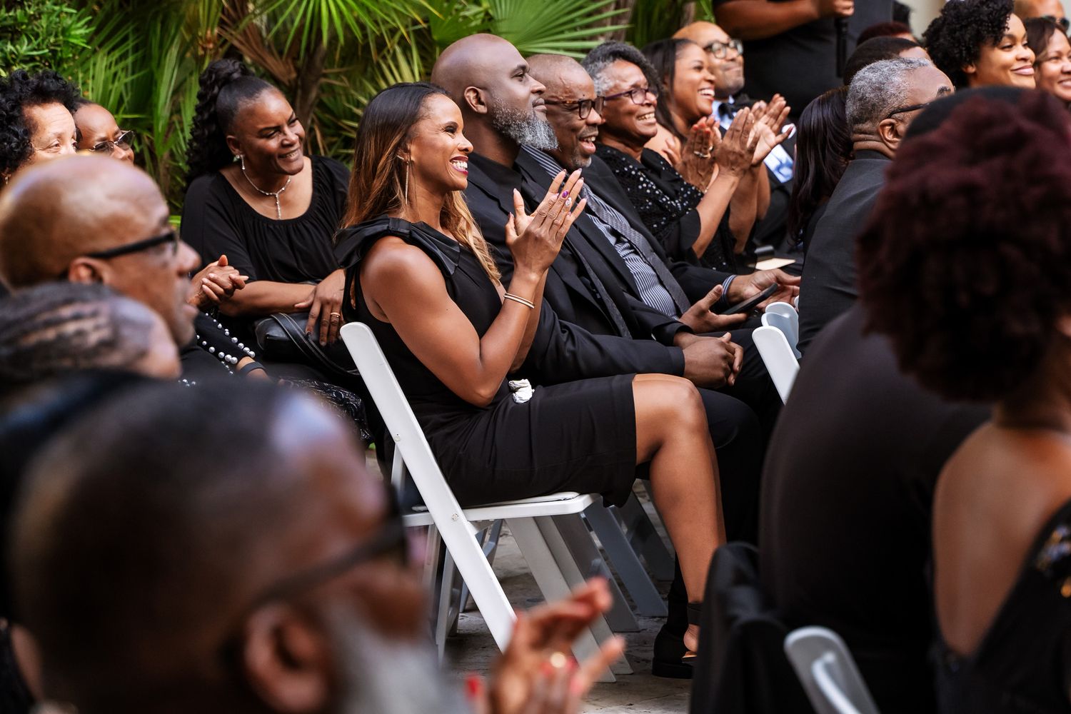 Wedding guests enjoying and reacting during an outdoor ceremony.