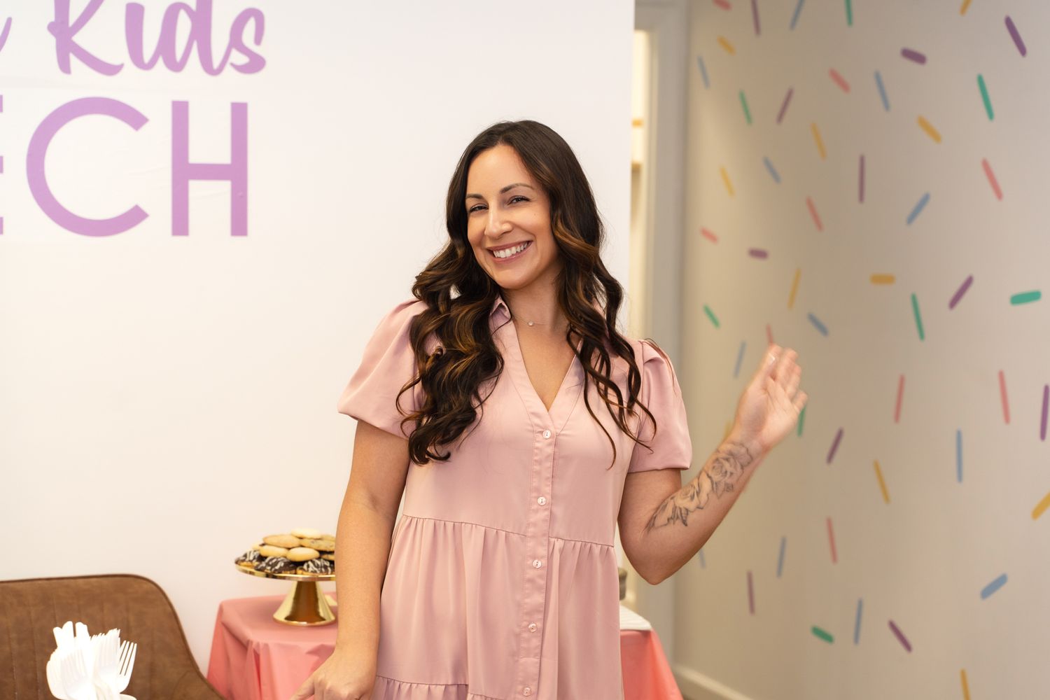 A speech therapy room decorated with confetti wall pattern and pink signage.