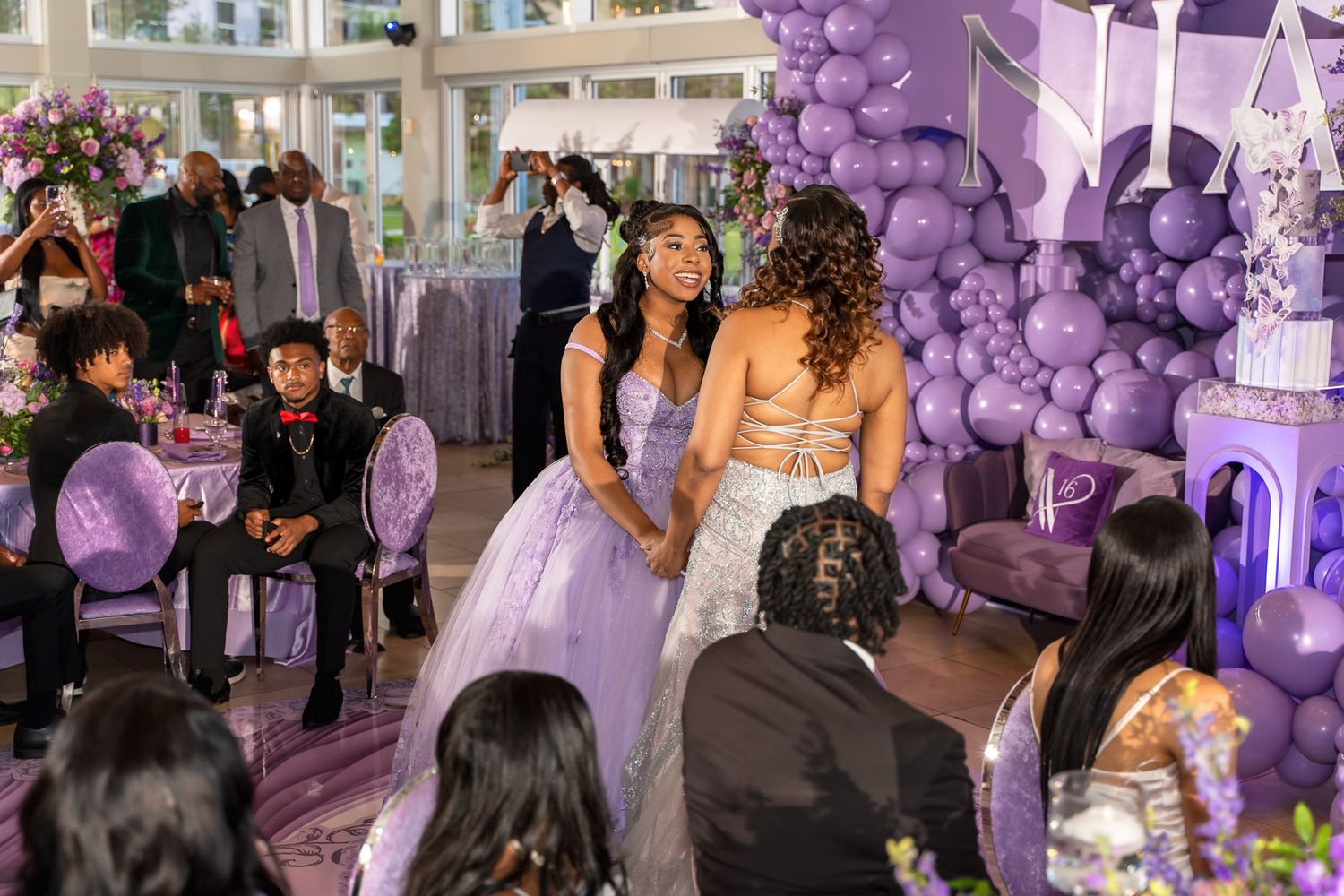 A celebration event featuring purple balloon decorations and formal attire.