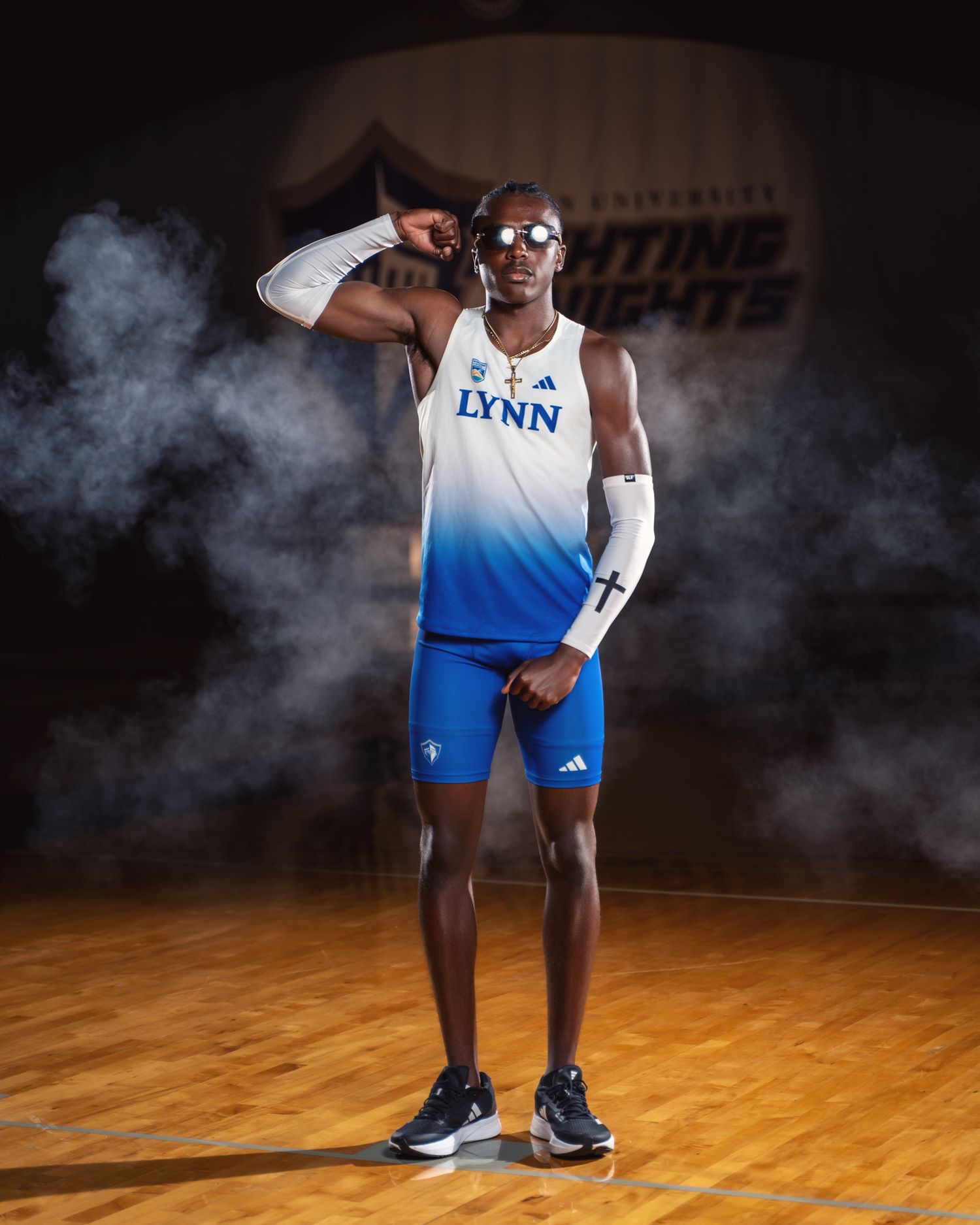 Lynn University athlete poses confidently with smoke effects on basketball court.