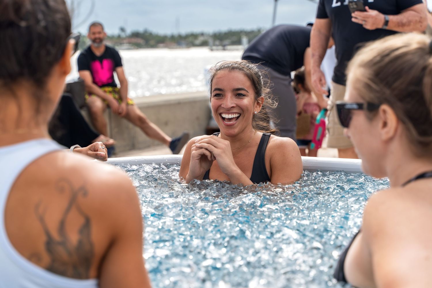 People enjoying conversation in an outdoor spa pool during a wellness gathering.