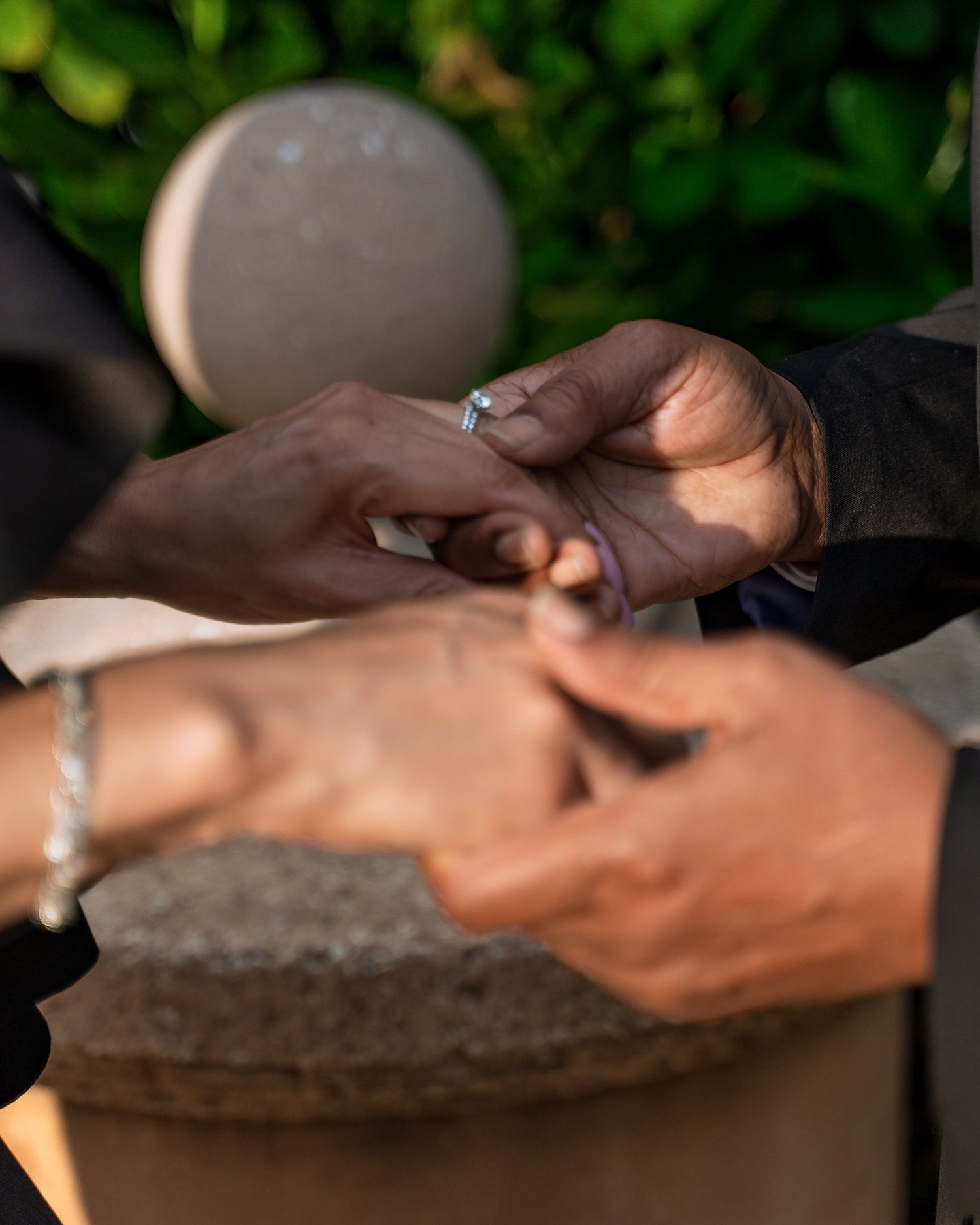 Close-up of hands exchanging rings during wedding ceremony.