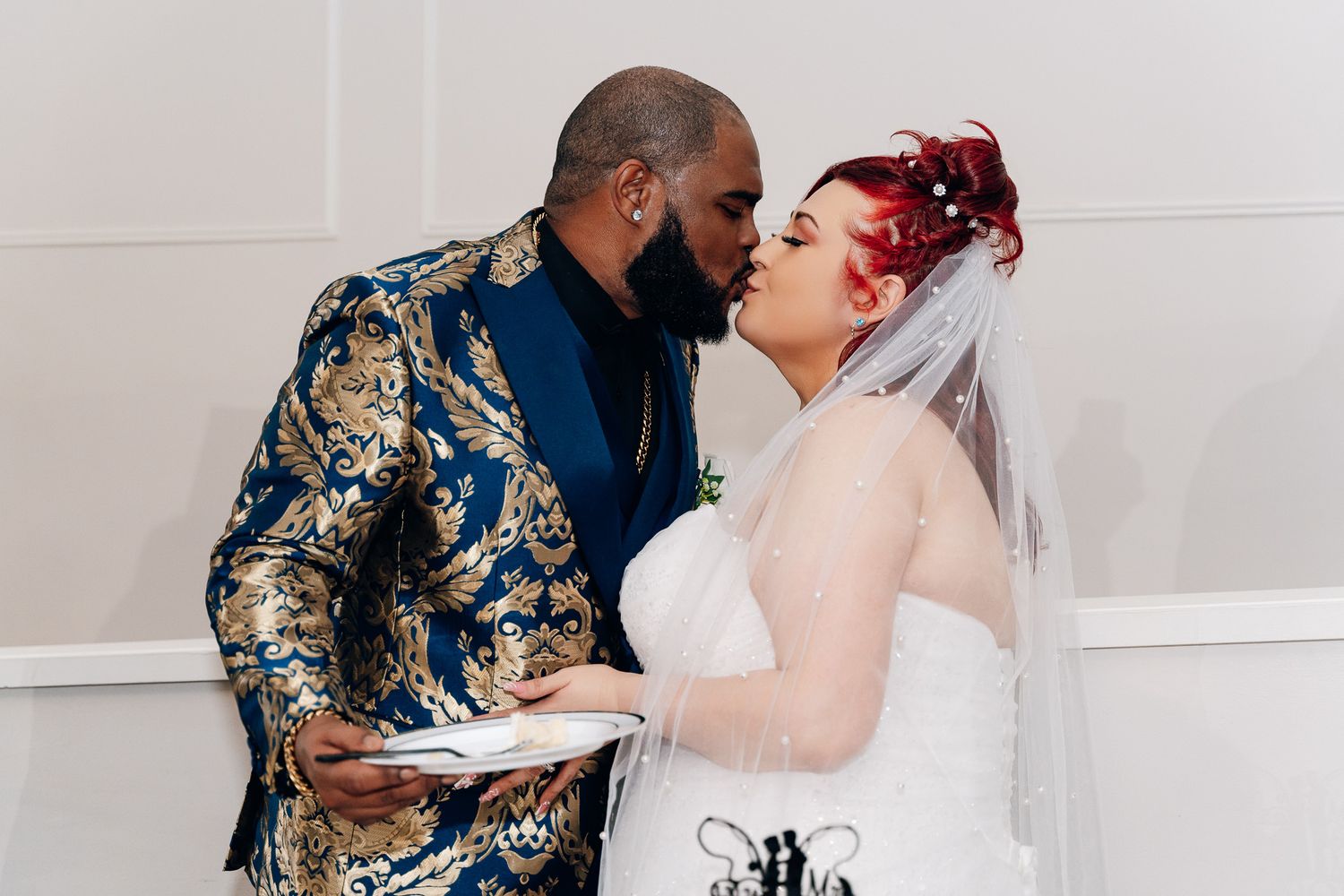 Intimate moment shared between couple at wedding reception with decorative backdrop.