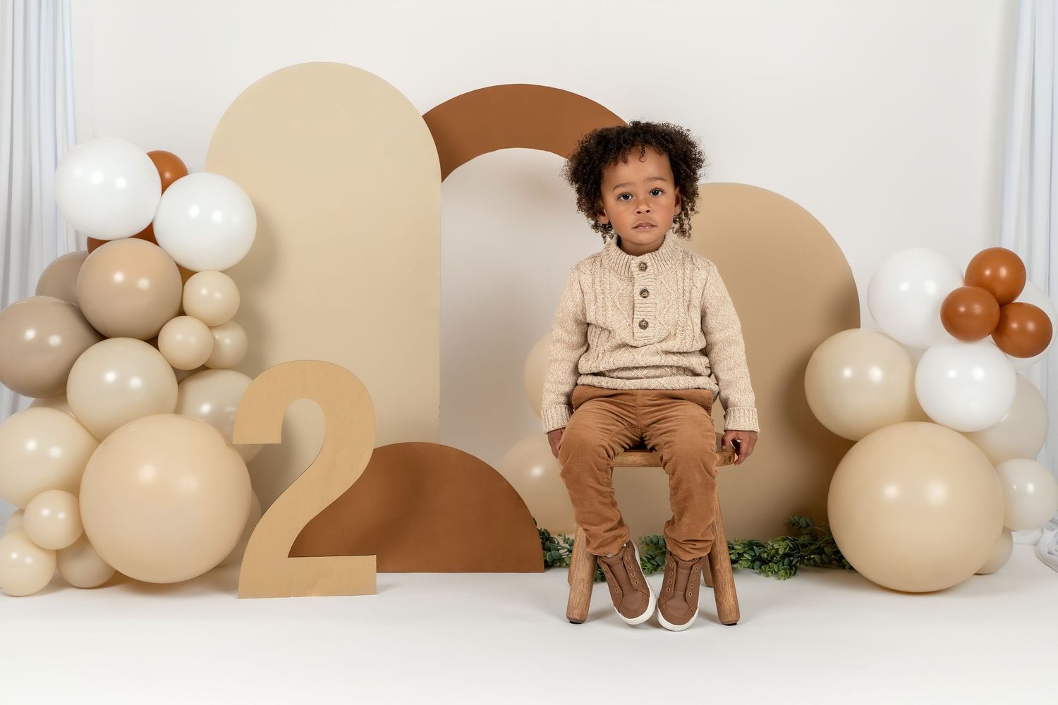 A minimalist photo collage with brown and cream tones featuring decorative balloons and plush toys against neutral backdrops.