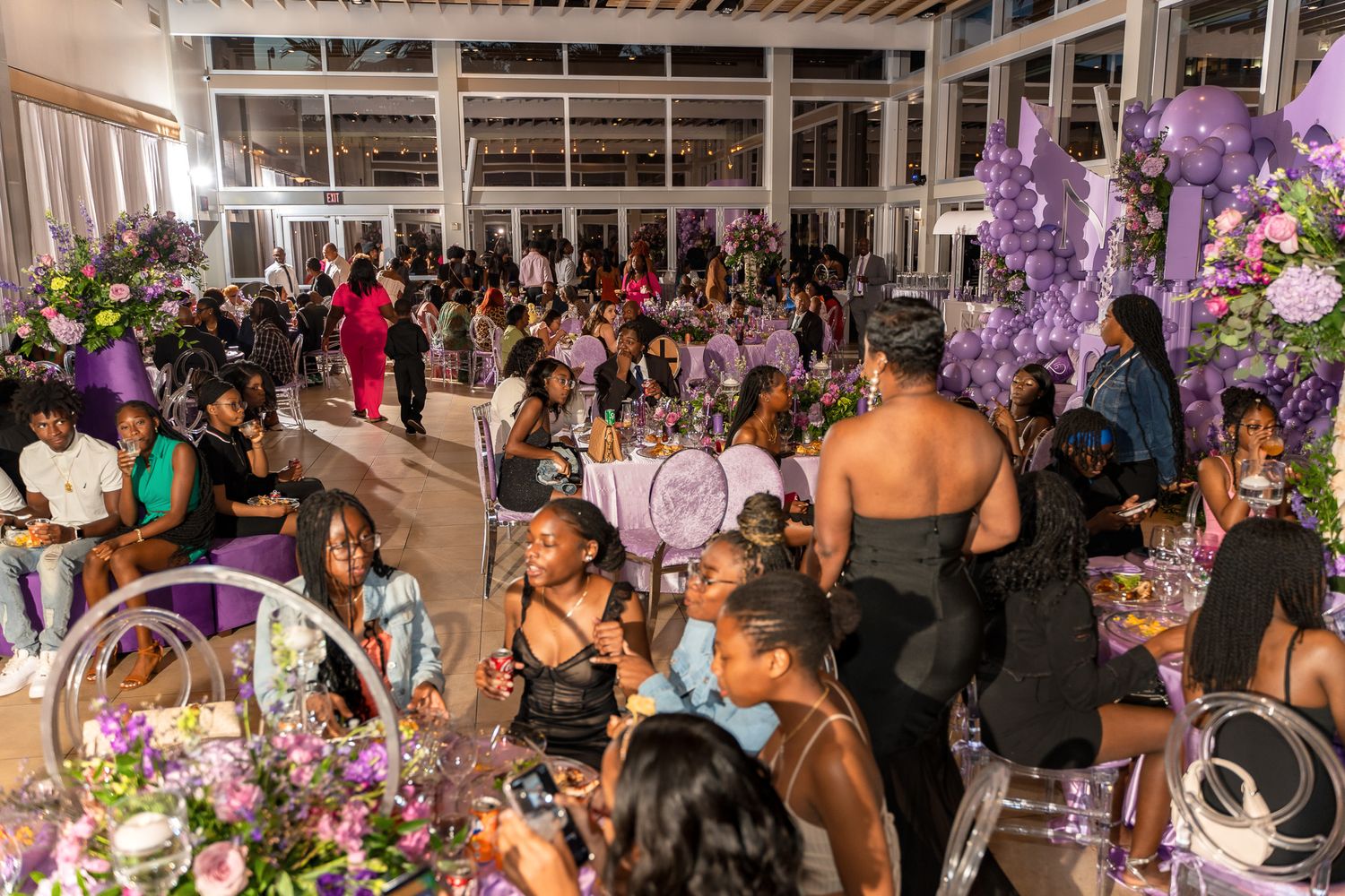 An elegant reception venue filled with guests seated at decorated tables for a special celebration.