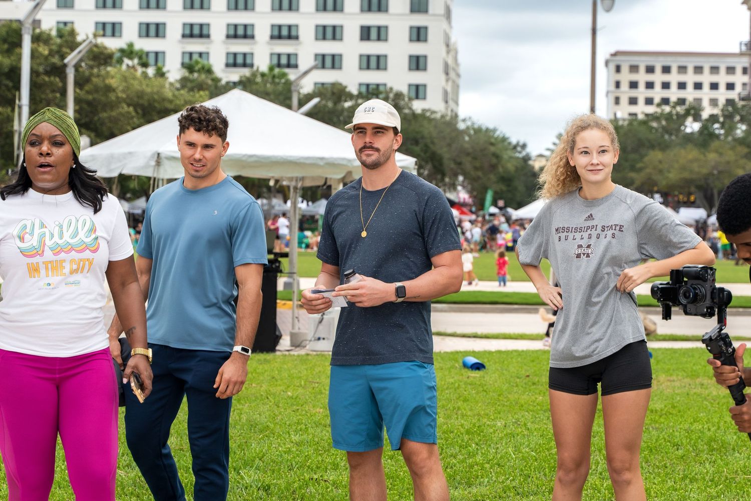 A group of people standing together on grass during an outdoor event.